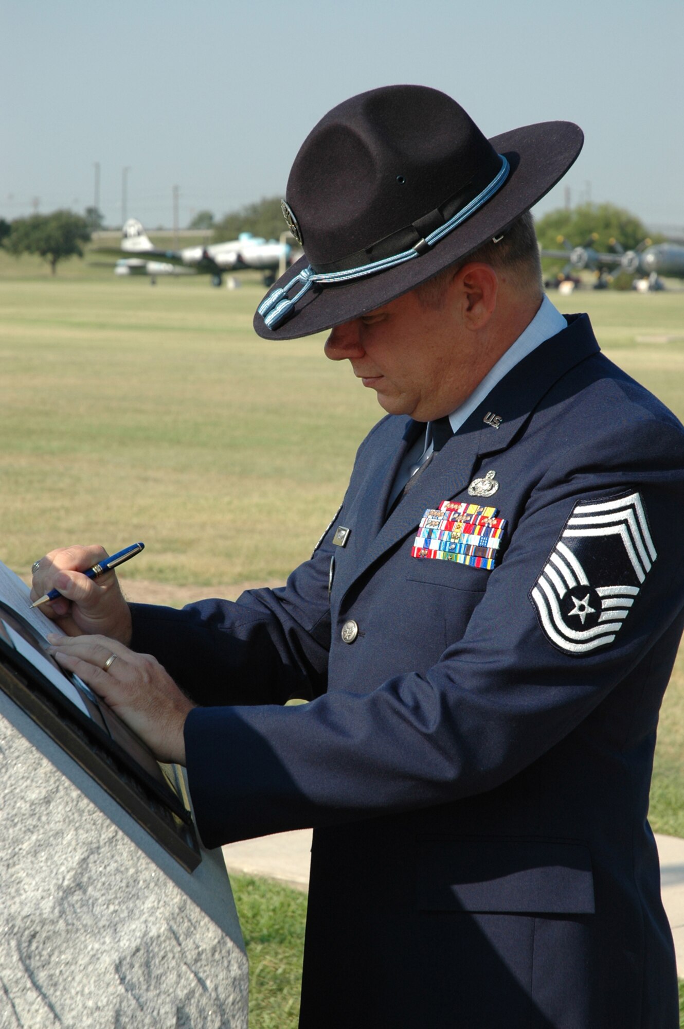 Chief Master Sgt. Steve Sargent, basic military training superintendent, signs his final re-enlistment paperwork at the Military Training Instructor Monument on the parade field at Lackland Air Force Base, Texas, June, 2005. Chief Sargent retired March 13, 2009, and served 30 years in the Air Force. (Courtesy photo)