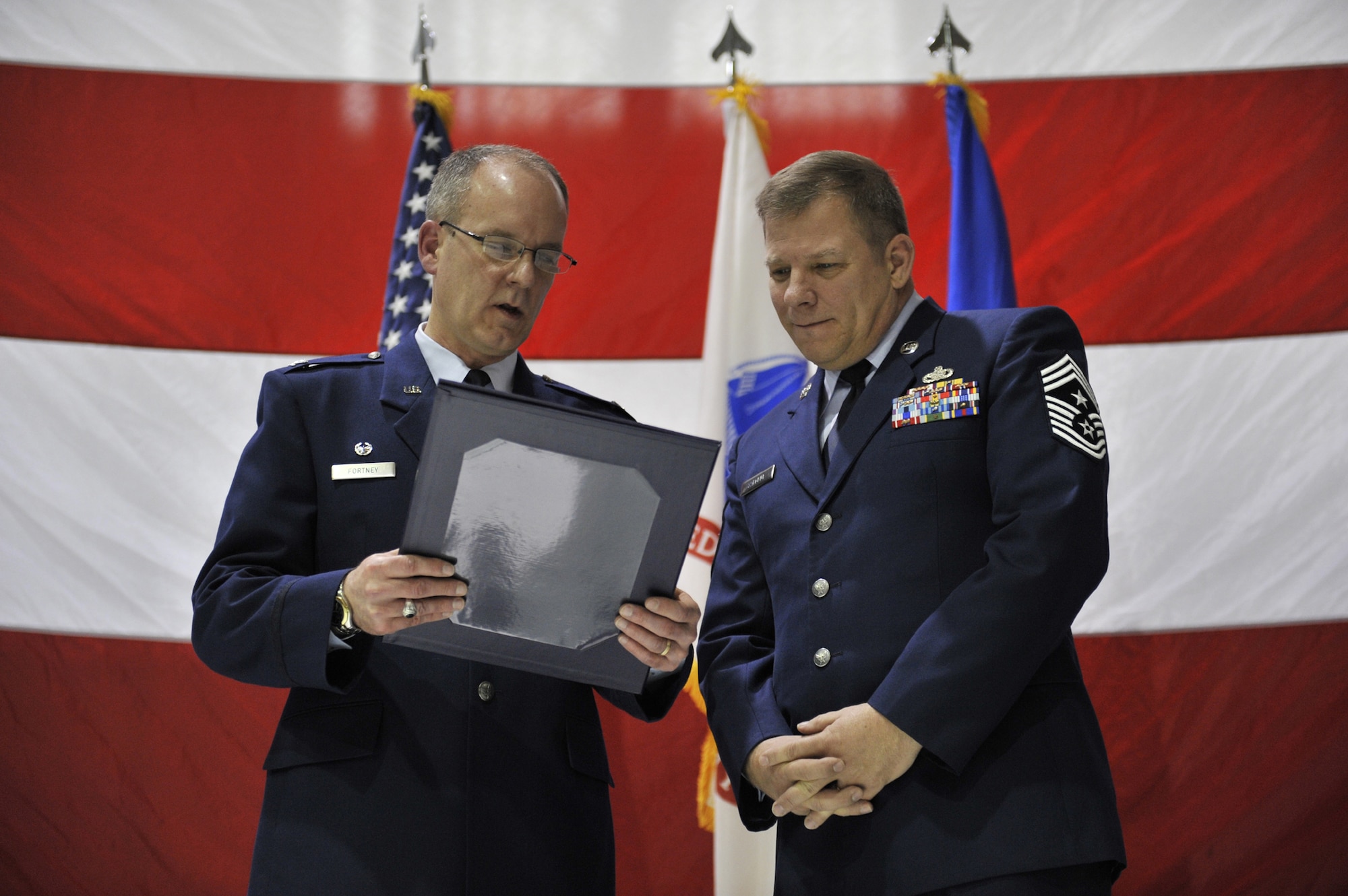 Col. Michael Fortney, 341st Missile Wing commander, reads Chief Master Sgt. Steve Sargent, 341st MW command chief master sergeant, one of several certificates marking his retirement orders March 13.  Chief Sargent served in the U. S. Air Force for 30 years.(U.S. Air Force photo/John Turner)
