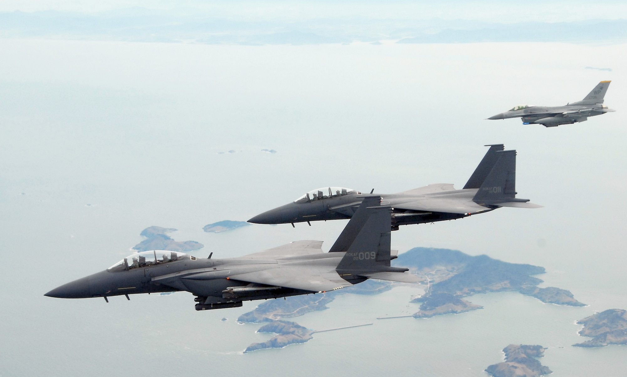 F-15K Slam Eagles from the South Korean air force's 11th Tactical Fighter Wing out of Daegu Air Base, fly with an F-16 Fighting Falcon March 11 over Kunsan Air Base, South Korea. The three aircraft were participating in the Buddy Wing program, an operation designed to increase U.S. Air Force and South Korean air force interoperability. (U.S. Air Force photo/Staff Sgt. Jason Colbert) 
