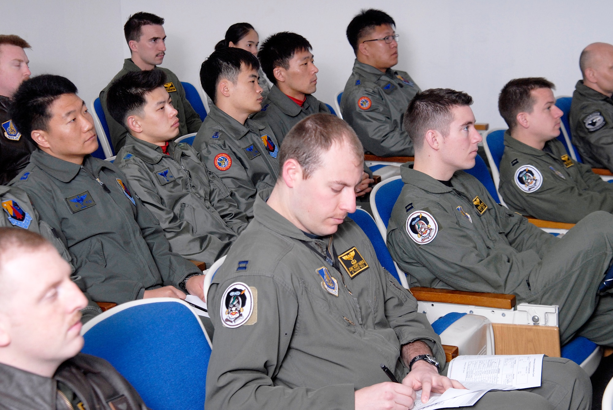 Airmen from the South Korean air force's 11th Tactical Fighter Wing out of Daegu Air Base sit in on a mass flight briefing with members of the 80th Fighter Squadron March 10 at Kunsan Air Base, South Korea. The South Korean air force pilots are here in support of the Buddy Wing program, an operation designed to increase U.S. Air Force and South Korean air force interoperability. (U.S. Air Force photo/Staff Sgt. Jason Colbert) 
