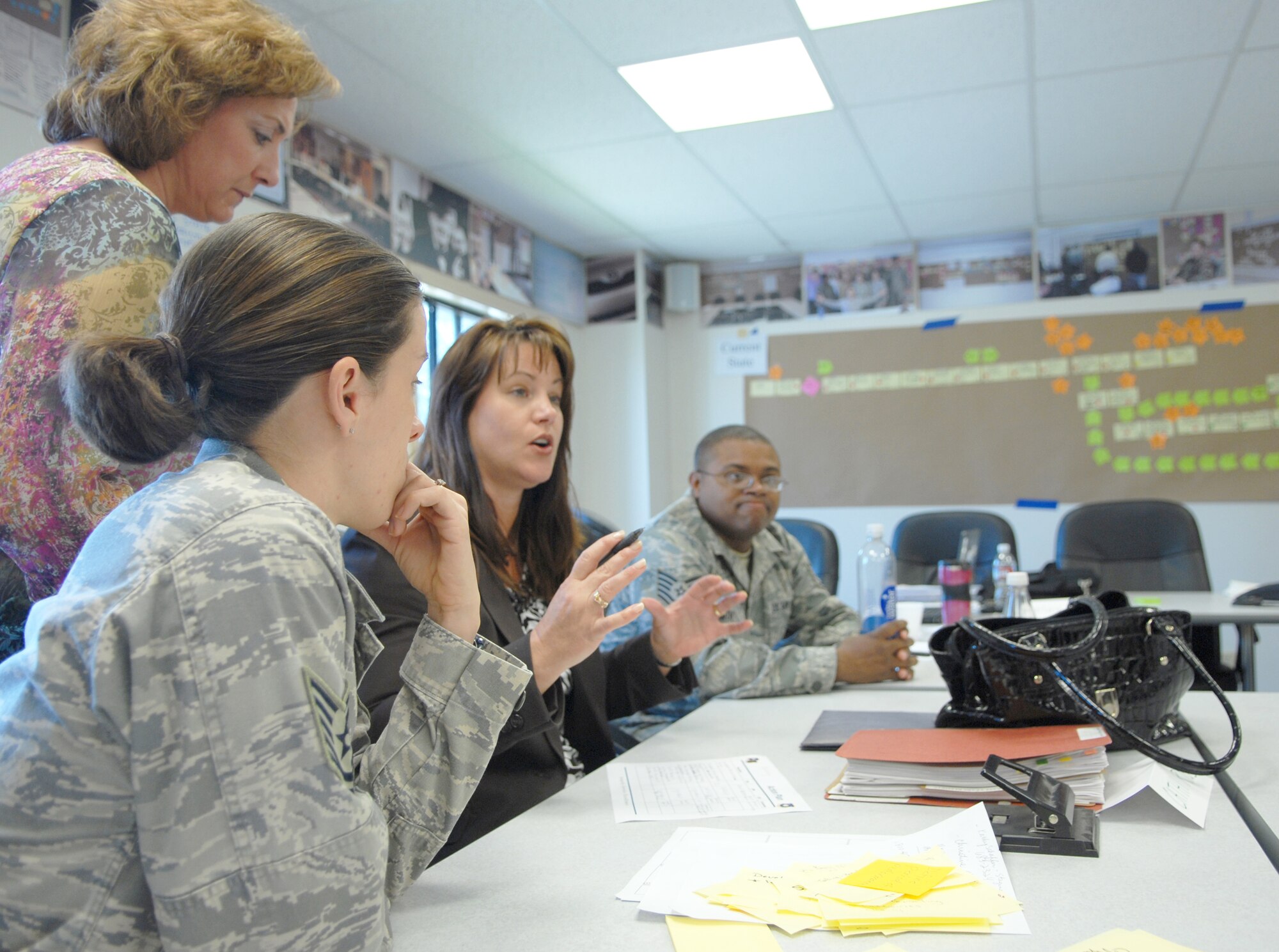 Members of the Air Force Smart Operations for the 21st Century, or AFSO 21, action team discuss ways to streamline the process for the production of the annual statement of assurance. The team used a successful eight-step method to trim a six-month process down to a two-month process. The ideas could have possible Department of Defemse implications. (U.S Air Force photo/Staff Sgt. Raymond Hoy)