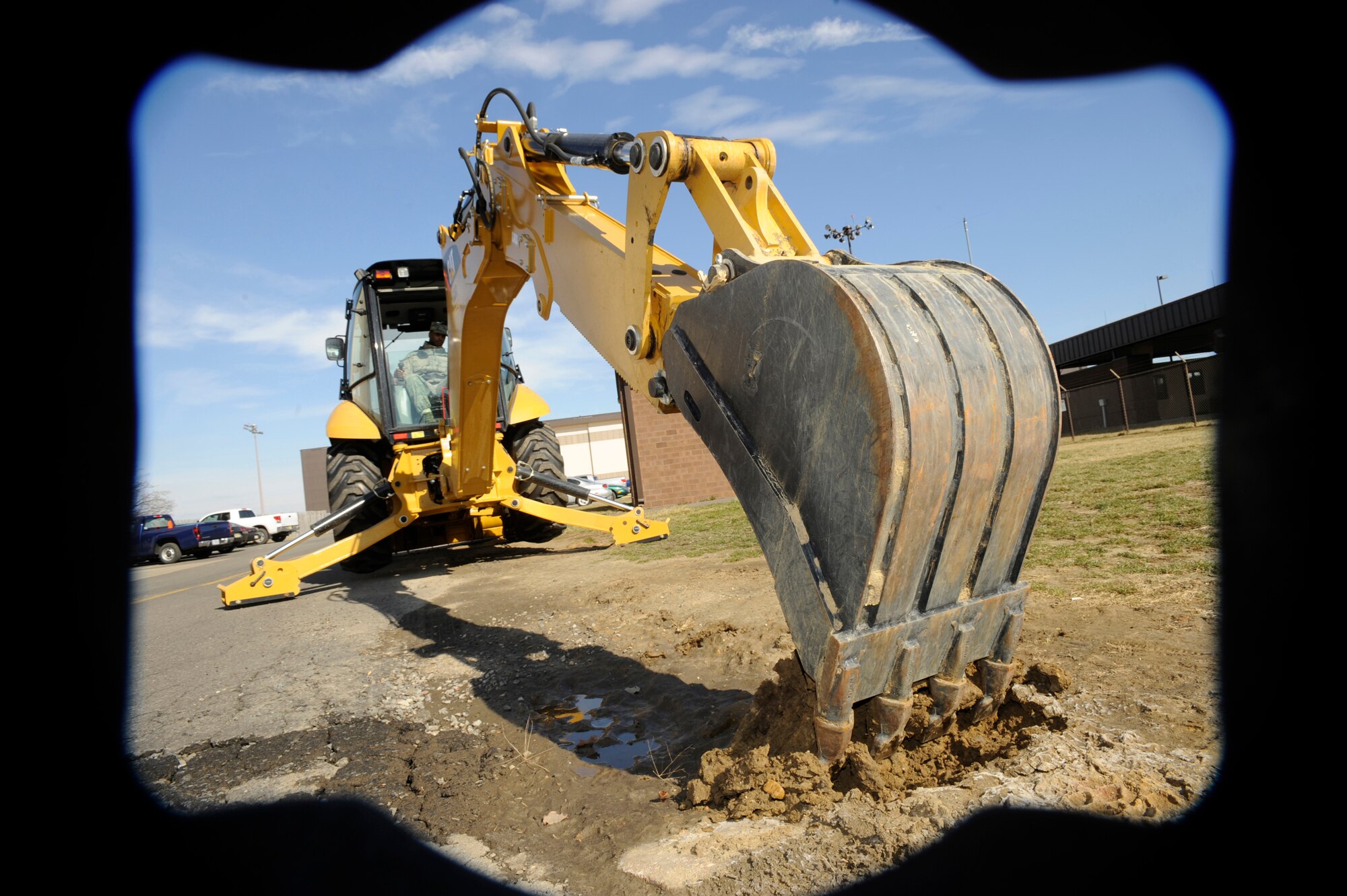 Senior Airman Phil McCain, 87th Civil Engineer Heavy Equipment Shop operator, operates a backhoe during a utility dig March 12. The backhoe is utilized by the 87th CES for various projects around the base, including water main brakes, utility line maintenance, high temperature water brakes, plowing snow, moving dirt and loading trucks with fill. (U.S. Air Force photo/Carlos Cintron)