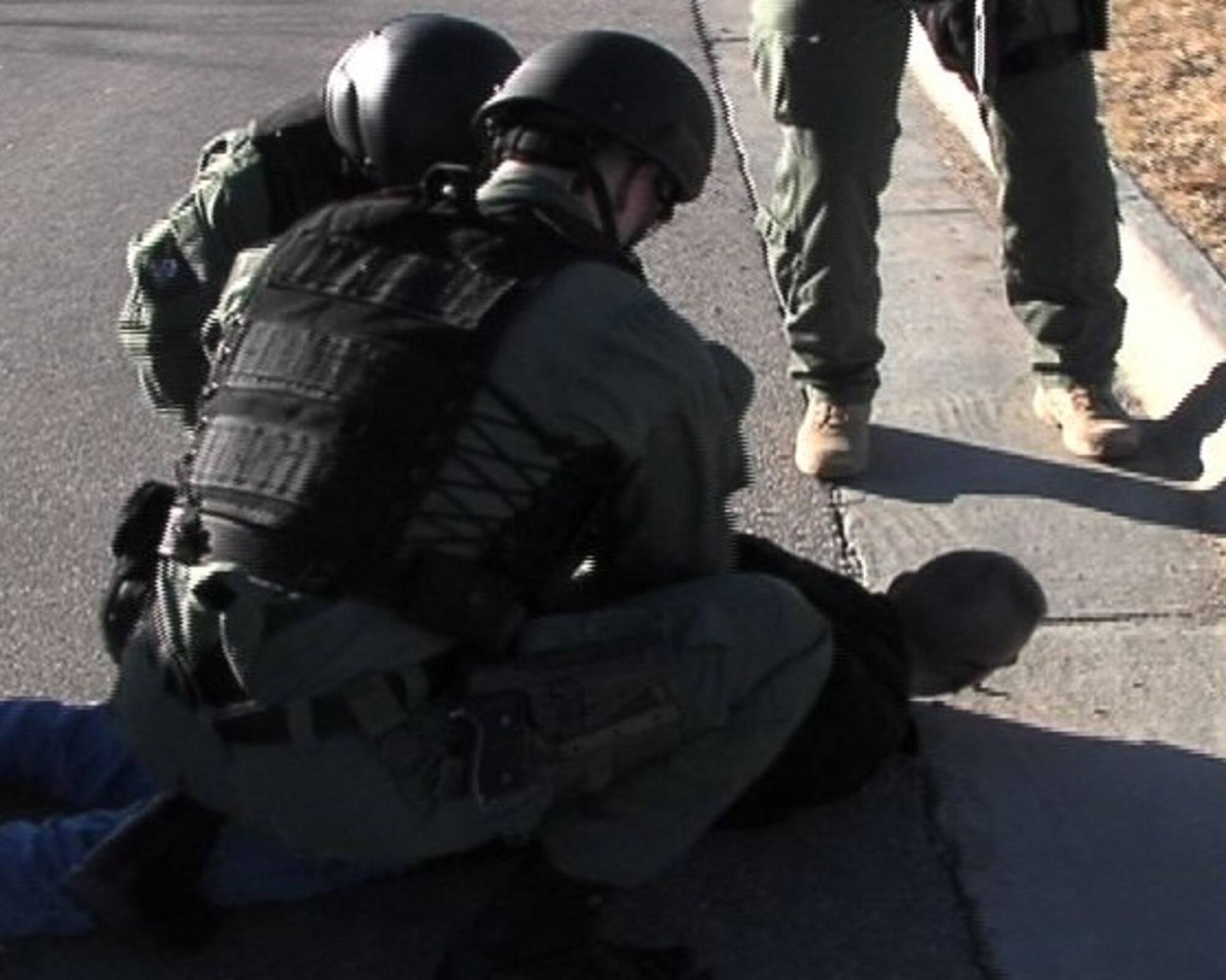 MCCONNELL AIR FORCE BASE, Kan. -- Team McConnell Emergency Services members apprehend a mock suspect during a vehicle scenario in base housing, Feb. 1. Following apprehension, suspects are turned over to a separate investigative agency for questioning.  (Photo by Senior Airman Nicholas Stowers)
