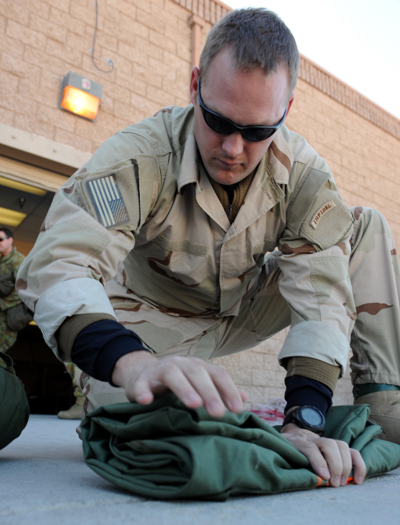 NELLIS AIR FORCE BASE, Nev., -- Tech. Sgt. Josh Tully, 99th Civil Engineer Squadron airborne firefighter from Nellis Air Force Base, Nev., prepares gear before participating in a Survival, Evasion, Resistance and Escape, or SERE, static line jump during Red Flag 09-3 March 5. SERE specialists prepare aircrews and other high-risk personnel to survive under any conditions. Red Flag, which concluded March 13, featured more than 90 aircraft, 2,000 personnel and 27 units from the United States military and its allies. (U.S. Air Force photo by Airman 1st Class Debbie Lockhart)