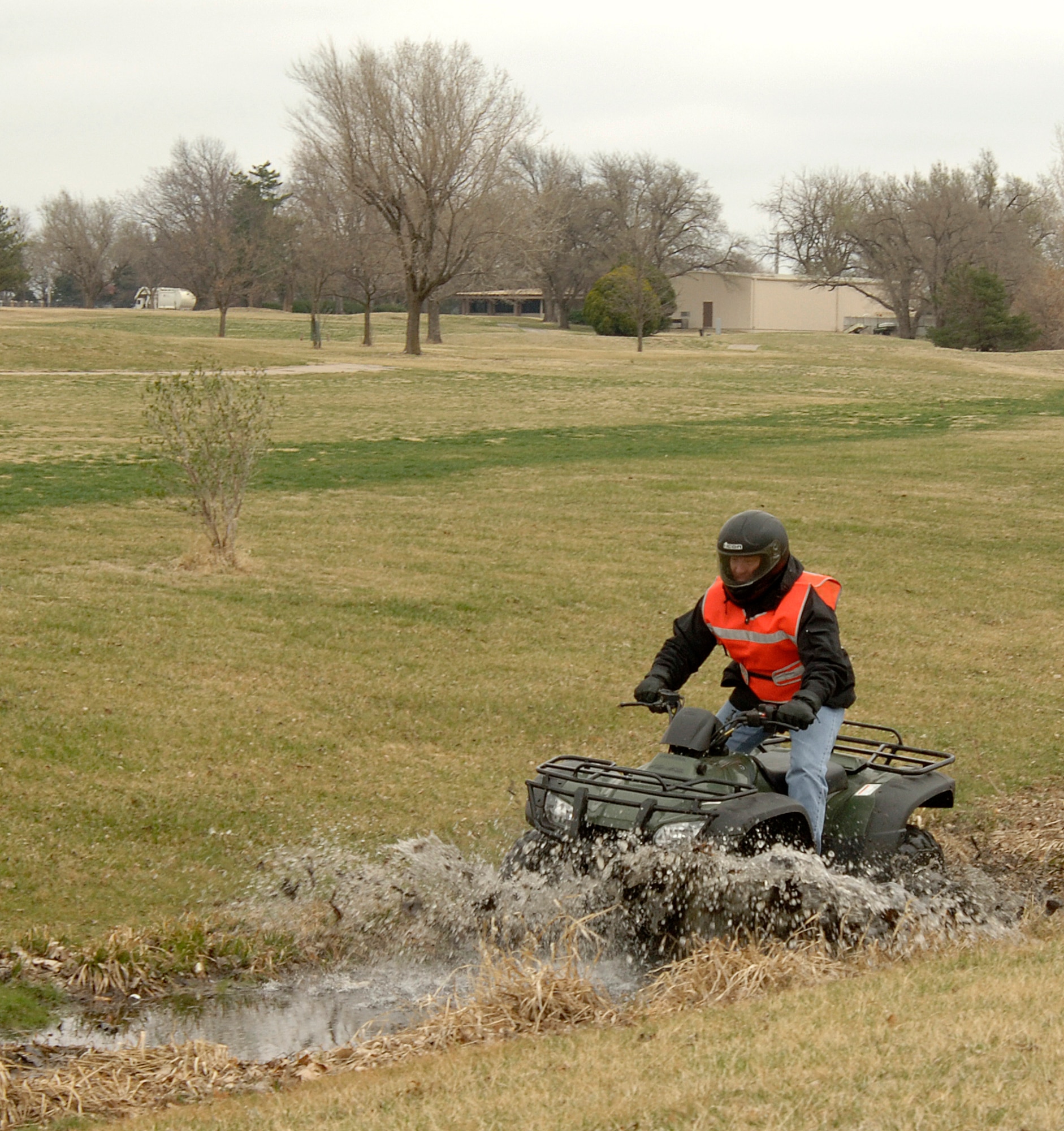 MCCONNELL AIR FORCE BASE, Kan. -- Master Sgt. Scot Steinaway, 22nd Force Support Squadron, splashes through a ditch while riding an all terrain vehicle near the Outdoor Recreation Center, March 16. Sergeant Steinaway received his license to teach ATV riding during a week long course. In order to become an instructor, Sergeant Steinaway had to help teach two individuals how to ride ATV’s. (Photo by Senior Airman Laura Suttles)