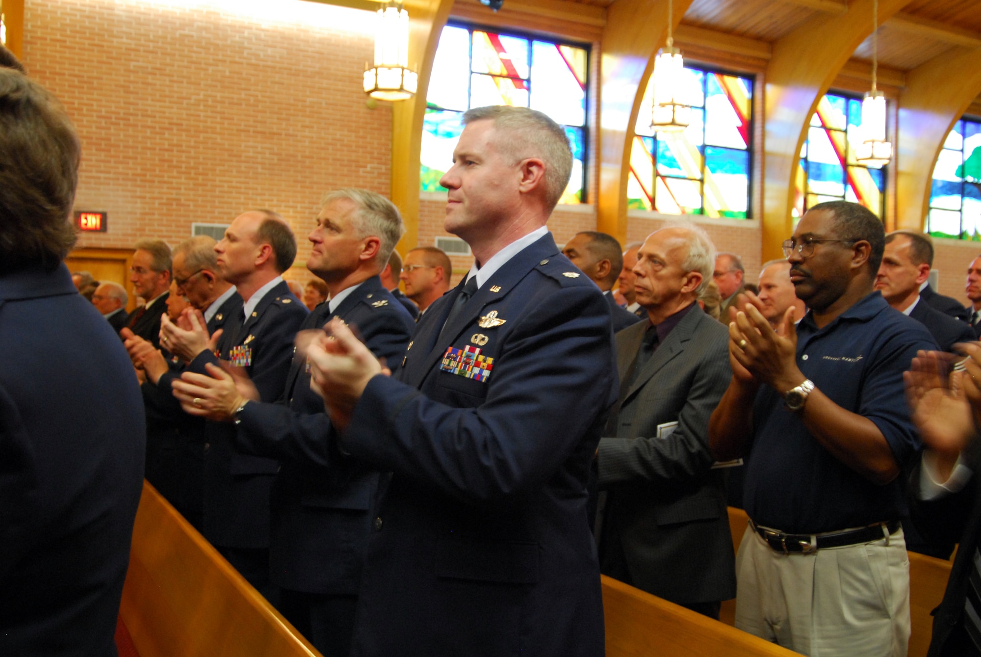 Those in attendance at the memorial service for the first Chief Master Sgt. of the Air Force, Paul W. Airey, clap loudly, rejoicing the life of the Air Force legend. This was in response to a request by the eighth Chief Master Sgt. of the Air Force, Sam Parish, who said though those present were there to mourn, they should also celebrate the life of Paul W. Airey with "resounding applause." (U.S. Air Force photo/Lisa Norman)