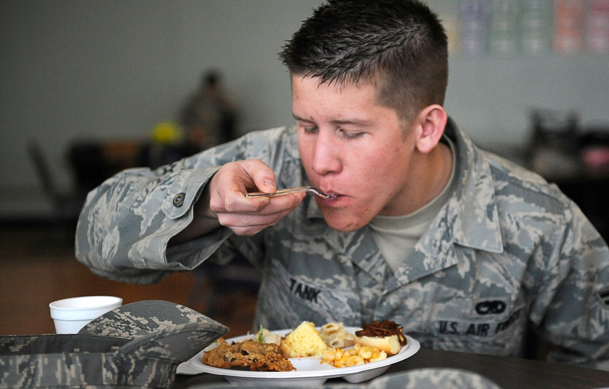 MOUNTAIN HOME AIR FORCE BASE, Idaho -- Airman 1st Class Kristopher Tank, 366th Equipment Maintenance Squadron, samples homemade dishes served at the Woman's History Month taste fest March 6 at the Community Center.  The base’s woman's heritage committee hosted the fest in honor of the annual heritage observance. (U.S. Air Force photo/ Senior Airman Stephany Miller)