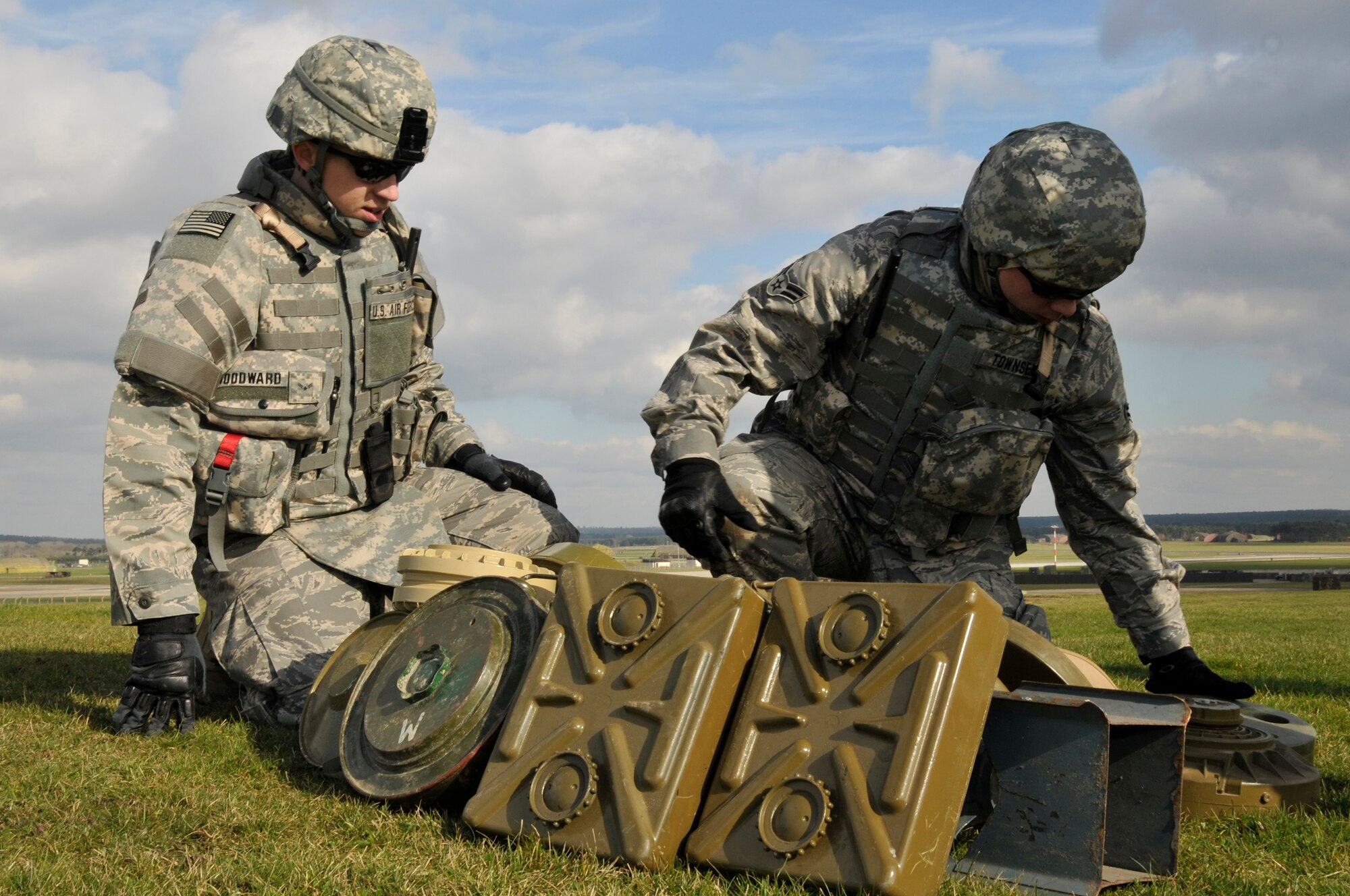 Airman 1st Class Rileigh Woodward and Airman 1st Class Christopher Townsend, 48th Civil Engineer Squadron explosive ordnance disposal team members, carefully arrange the simulated mines and explosives so they will be successfully destroyed March 6, 2009 at RAF Lakenheath, England. EOD Airmen participated in a ground assault exercise which involves maneuvering to a location on foot to complete an objective. (U.S. Air Force photo by Airman 1st Class Perry Aston)