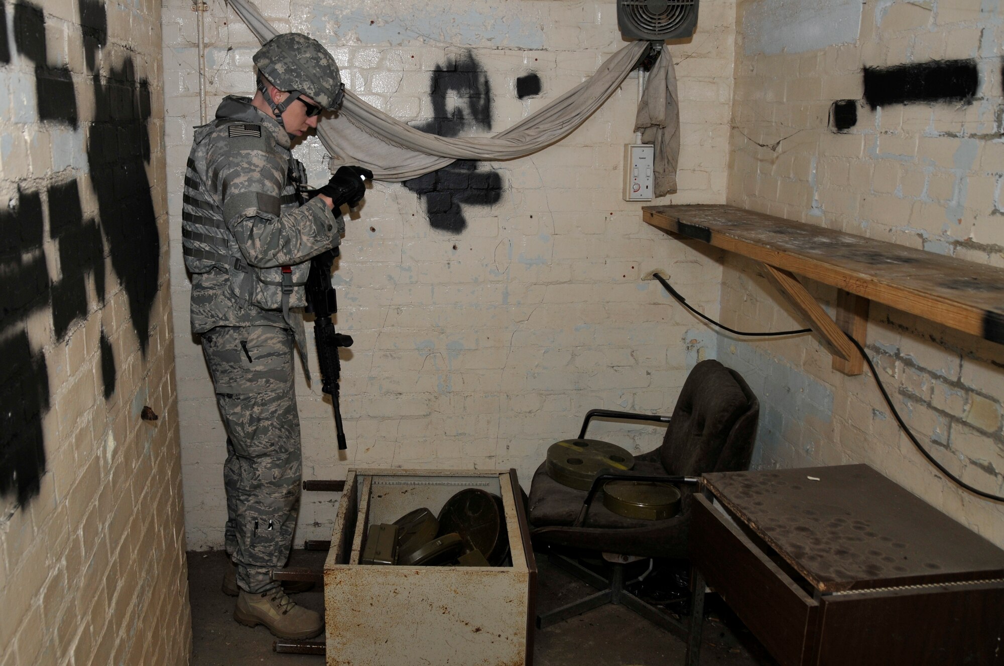 Airman 1st Class Rileigh Woodward, 48th Civil Engineer Squadron explosive ordnance disposal team member, photographs the weapons cache March 6, 2009 at RAF Lakenheath, England. Airman Woodward document the cache so the weapons can identified. (U.S. Air Force photo by Airman 1st Class Perry Aston)