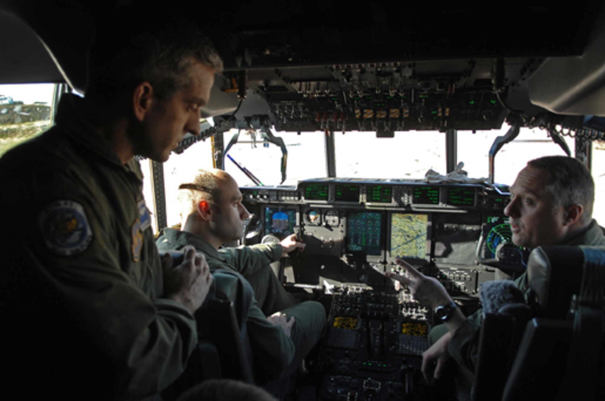 Rhode Island Air National Guard Lt. Col. Joe Francoeur (right), Executive Officer and Intructor Pilot conducts re-qualification training with U.S. Air Force Lt.Col. Craig Williams (standing) and Maj. Michael Ramirez, both C-130 pilots with the 37th Airlift Squadron. The Rhode Island Air National Guard brought the C-130J aircraft to Bezmer Air Base, Bulgaria to train and conduct air crew qualications for air crew and pilots like Lt.Col. Williams and Maj. Ramirez,  during Operation Thracian Spring , Bezmer Air Base, Bulgaria, March 9, 2009. Conducted annually since 2007, Operation Thracian Spring is a two week exercise allowing U.S. forces an opportunity to train and interact with their Bulgarian counterparts. (U.S. Air Force photo by Airman 1st Class Tony R. Ritter)