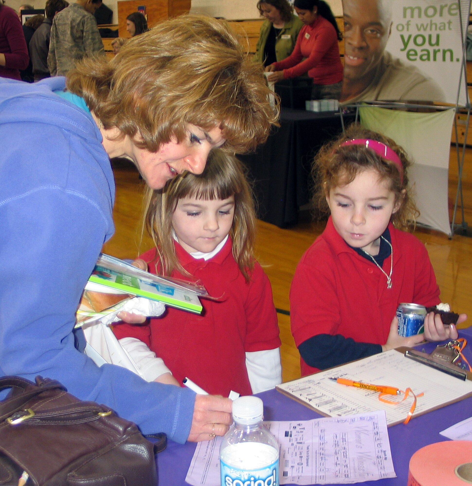 From left, Susan Fischer, along with daughters Autumn and Alyssa, fill out the fair evaluation for their chance at one of four grand prizes at the Women’s Wellness Fair Thursday, March 12. (U.S. Air Force photo by Melissa Seror)