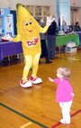 Macy Perigo, 16 months, enjoys dancing with Bobby the Banana while attending the Women’s Wellness Fair with her family Thursday, March 12. (U.S. Air Force photo by Melissa Seror)
