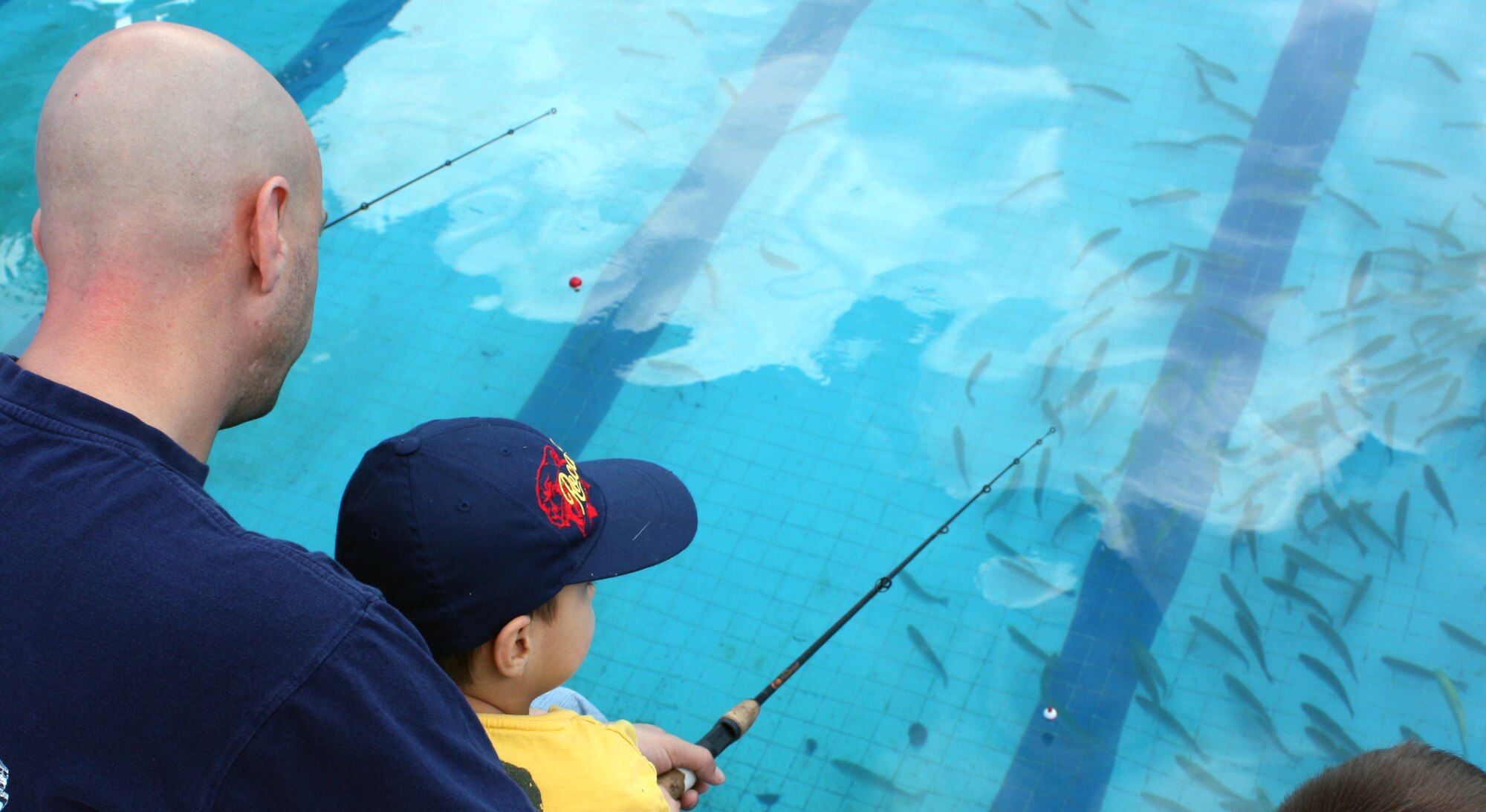 Tech. Sgt. Sascha Harmon, 39th Communications Squadron, and his son Cameron wait for a bite while at the base pool during the Fishing Rodeo March 14. Approximately 400 trout were placed in the pool for the weekend event, giving the Incirlik community a chance to catch their dinner. The pool was drained and cleaned before and after the event. (U.S. Air Force photo/Staff Sgt. Chris Galindo)