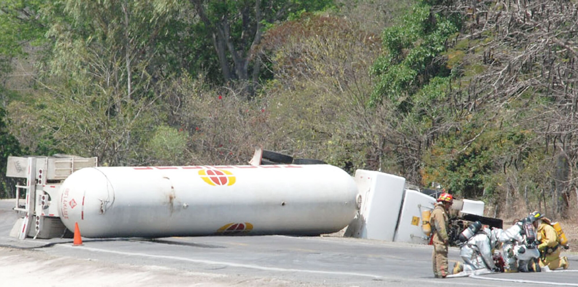Firefighters from Comayagua and Soto Cano Air Base, Honduras, set up a water hose to cool an overturned fuel tanker approximately 8 kilometers north of the base March 13 in Honduras. The tanker overturned after hitting a horse around 8 a.m. and caused traffic to be halted in both directions for more than 24 hours. (U.S. Air Force photo/Tech. Sgt. Rebecca Danet) 
