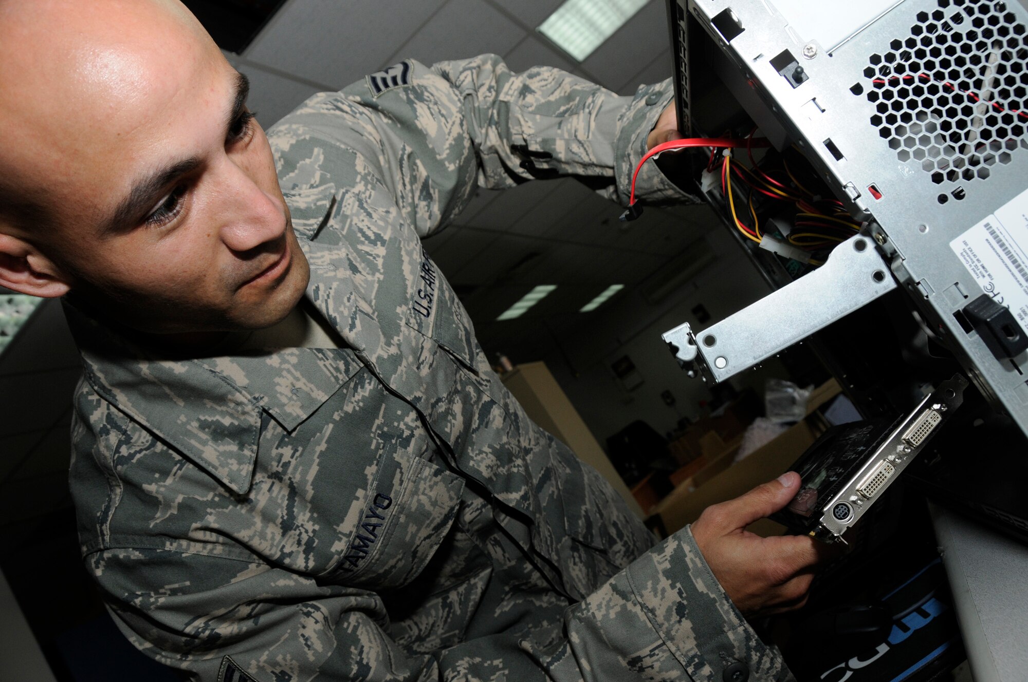SOUTHWEST ASIA - Staff Sgt. Antonio Tamayo, 380th Expeditionary Communications Squadron replaces a video card in a computer, Mar 17.  Sergeant Tamayo provides computer support for wing leadership and any distinguished visitors prior to their arrival. Sergeant Tamayo is deployed from Langley AFB, Va. (U.S. Air Force photo by Senior Airman Brian J. Ellis) (Released)