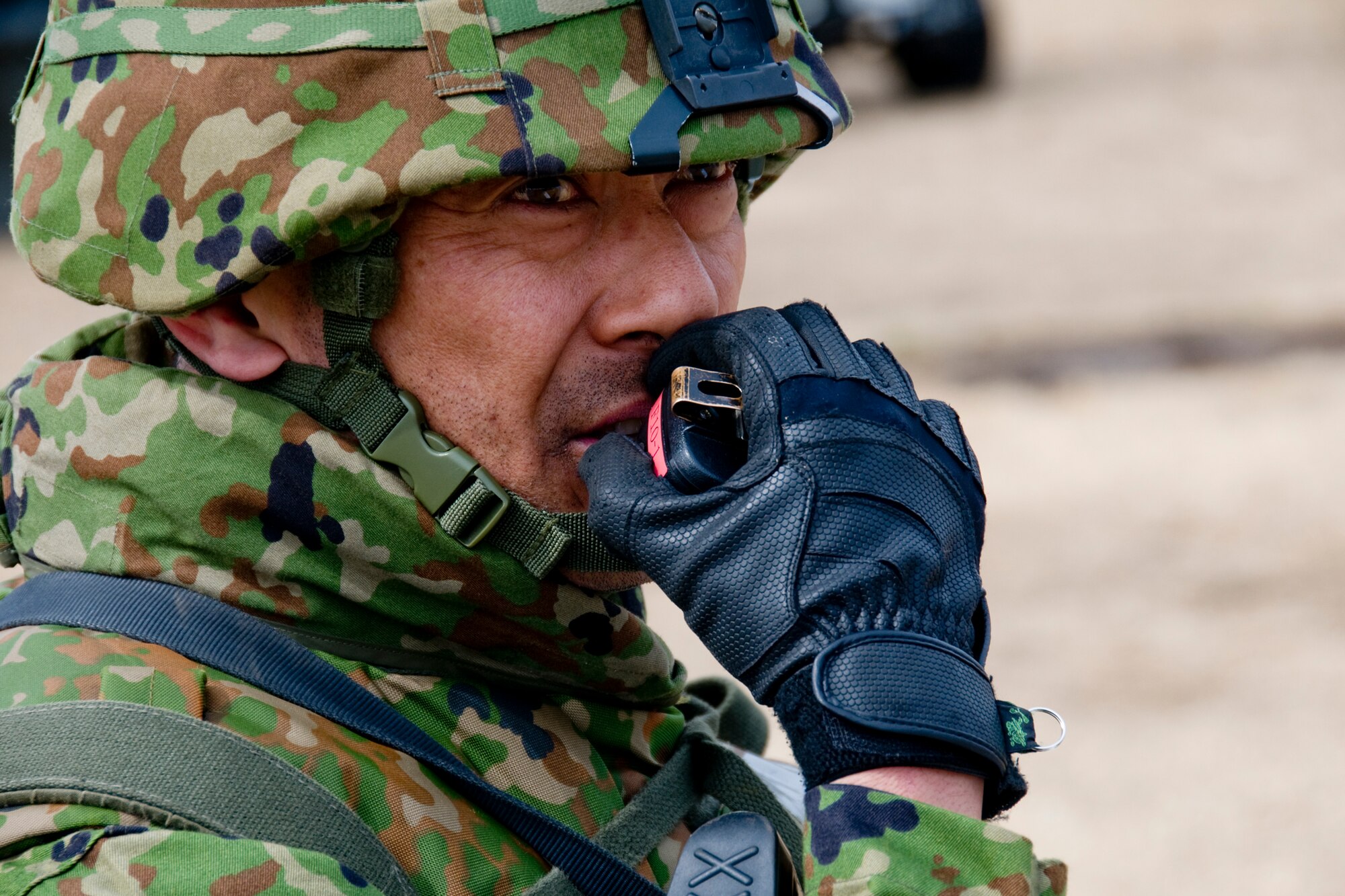 MISAWA AIR BASE, Japan -- Second Lt. Fumiko Aizu, Japan Ground Self-Defense Force, relays instructions to his troops over a radio during Exercise Guard and Protect March 13, 2009. The exercise brought together members of the JGSDF, Japan Air Self Defense Force, and the U.S. Air Force to practice defending Misawa Air Base against potential threats. (U.S. Air Force photo by Staff Sgt. Rachel Martinez)