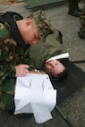 Navy Petty Officer 1st Class Anatalio Reyes (left), a hospital Corpsman assigned to Chemical Biological Incident Response Force, II Marine Expeditionary Force, documents information on Navy Petty Officer 3rd Class Brad Farber, simulated casualty, a hospital corpsman assigned to 2nd Medical Battalion, Camp Lejeune, N.C. CBIRF’s corpsmen are tasked with documenting where casualties go from the unit’s medical stabilization tent for possible follow-on medical care.