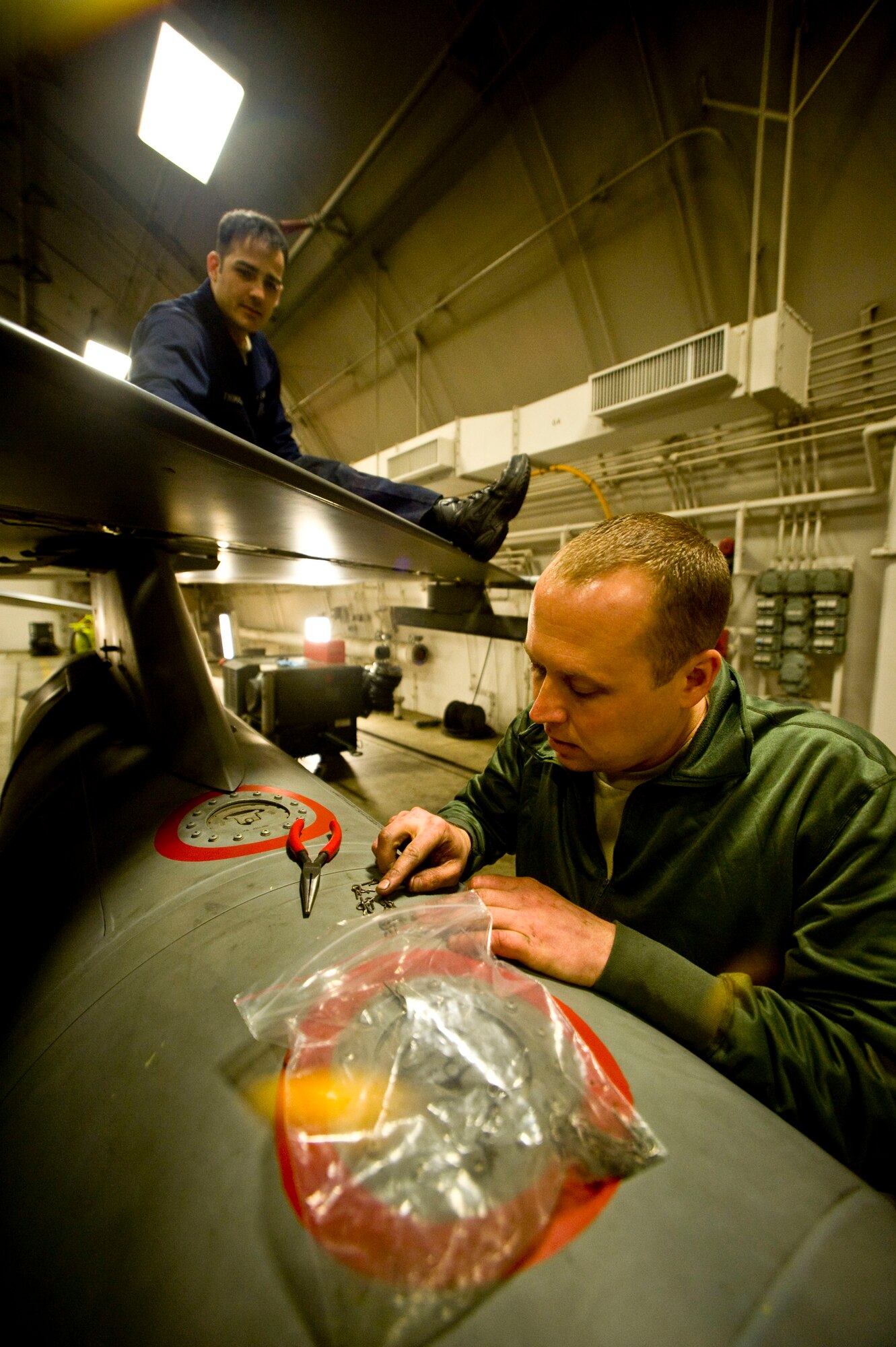 MISAWA AIR BASE, Japan -- Tech. Sgt. Nathan Bechdolt, F-16 Fighting Falcon crewchief, grabs a safety clip to repair the leading edge flap of an F-16 March 6, 2009. Sergeant Bechdolt, deployed to Misawa Air Base from the Air National Guard's 122nd Fighter Wing, Fort Wayne, Ind., worked side-by-side with Staff Sgt. William Thomas, 14th Aircraft Maintenance Unit crewchief, to bring the jet up-to-date with scheduled maintenance. (U.S. Air Force photo by Staff Sgt. Samuel Morse)