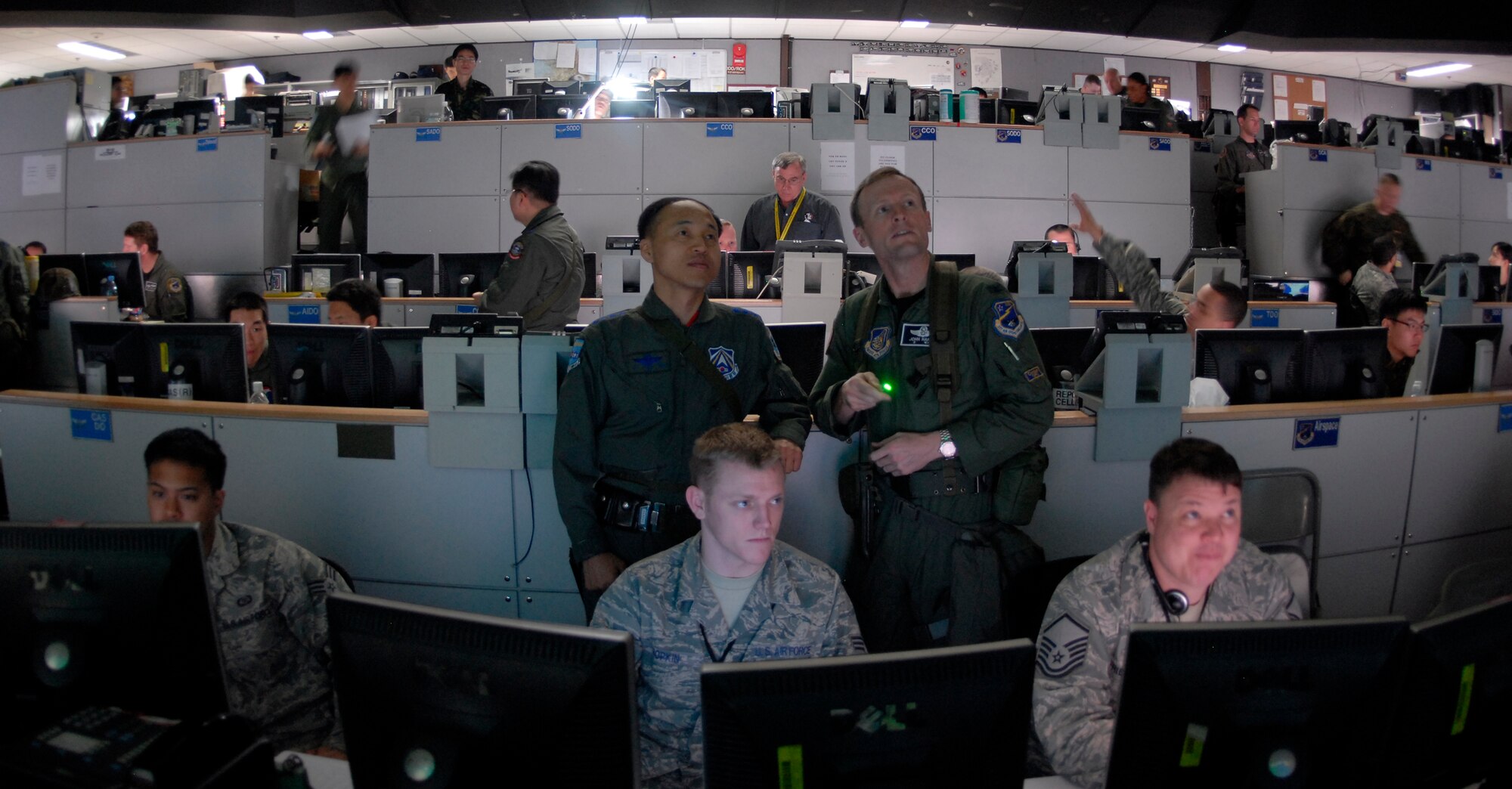 OSAN AIR BASE, Republic of Korea -- Military members at the Hardened Tactical Air Component Command operations floor at Osan AB, Korea, keep a watchful eye on simulated friendly and enemy air and ground forces during Exercise Key Resolve/Foal Eagle 09. Through a series of computer networks and giant data walls, a joint team of Americans and Republic of Korea Air Force counterparts exercise their warfighting capabilities. The annual air and space portion of Key Resolve/Foal Eagle demonstrates U.S. resolve to support the Republic of Korea against external aggression while improving ROK-U.S. combat readiness and joint/combined interoperability. (U.S. Air Force photo by Staff Sgt. Benjamin Rojek)