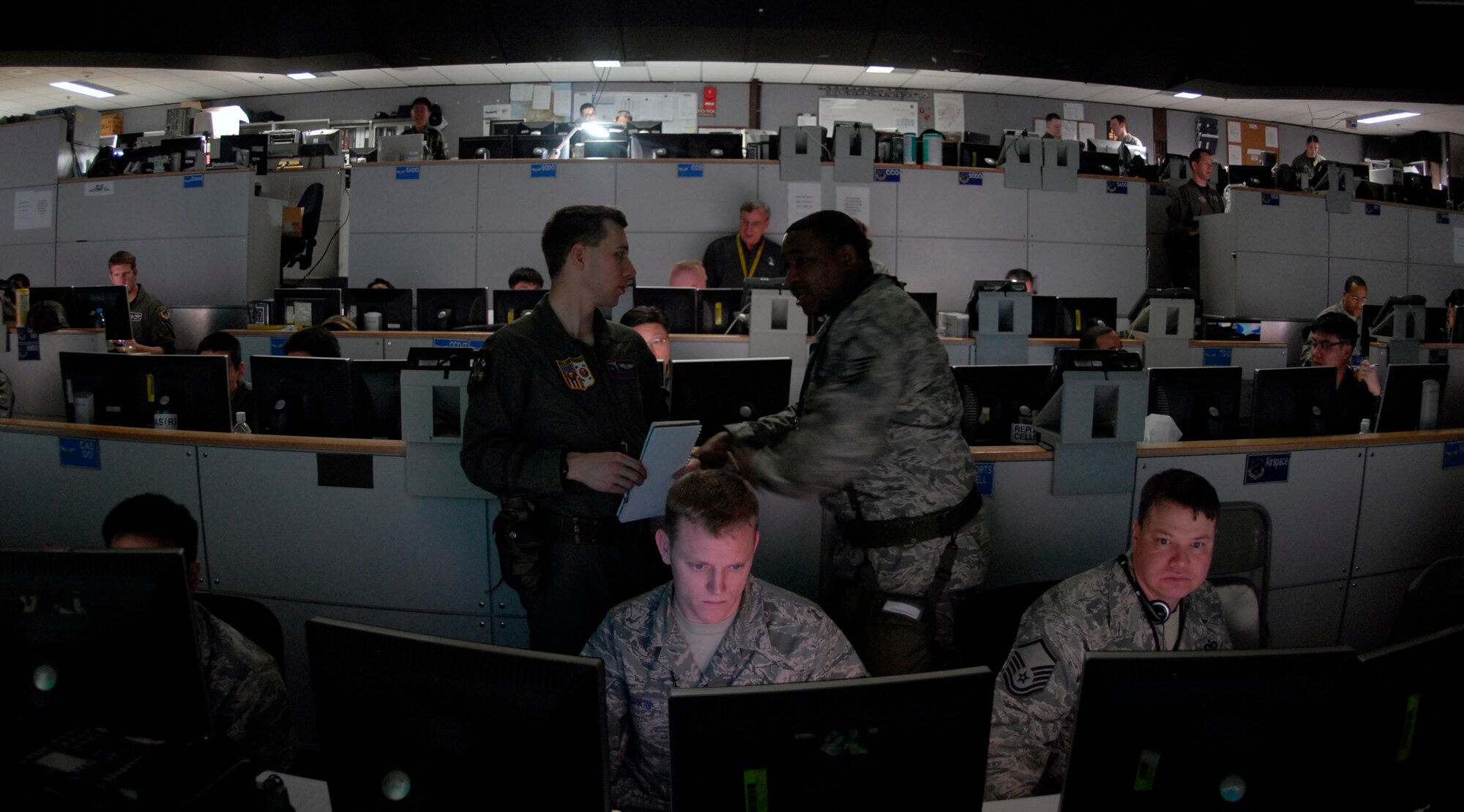 OSAN AIR BASE, Republic of Korea --  Military members at the Hardened Tactical Air Component Command operations floor at Osan AB, Korea,  keep a watchful eye on simulated friendly and enemy air and ground forces during Exercise Key Resolve/Foal Eagle 09. Through a series of computer networks and giant data walls, a joint team of Americans and Republic of Korea Air Force counterparts exercise their warfighting capabilities. The annual air and space portion of Key Resolve/Foal Eagle demonstrates U.S. resolve to support the Republic of Korea against external aggression while improving ROK-U.S. combat readiness and joint/combined interoperability. (U.S. Air Force photo by Staff Sgt. Benjamin Rojek)