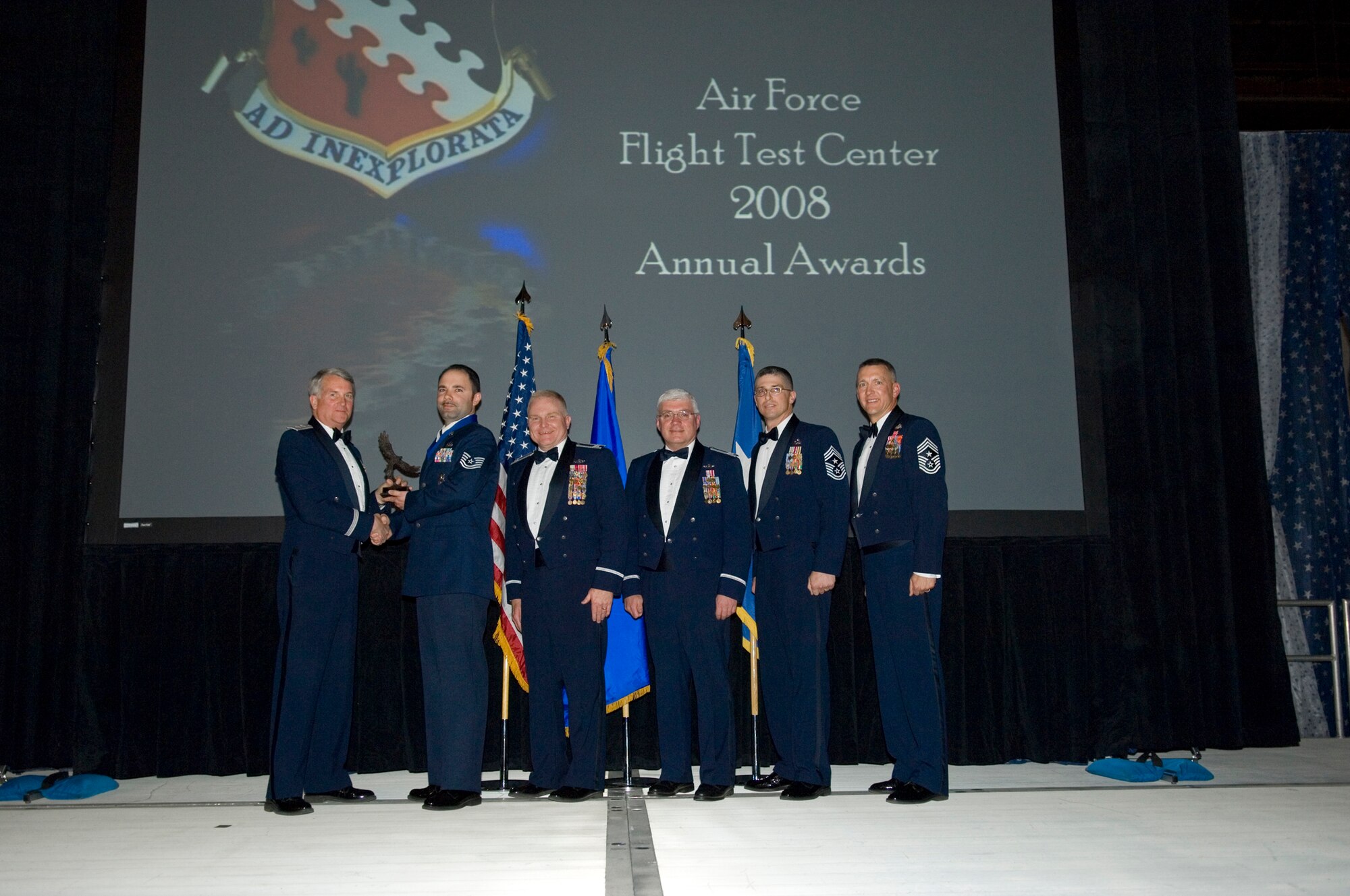 Tech. Sgt. Michael Rickman (second from left), 95th Security Forces Squadron Physical Security noncommissioned officer in charge, accepts the Air Force Flight Test Center Team of the Year award in behalf of the Installation Security Section Team from Maj. Gen. David Eichhorn, AFFTC commander, during an award ceremony at Hangar 1820 March 13. (U.S. Air Force photo/Mike Cassidy)