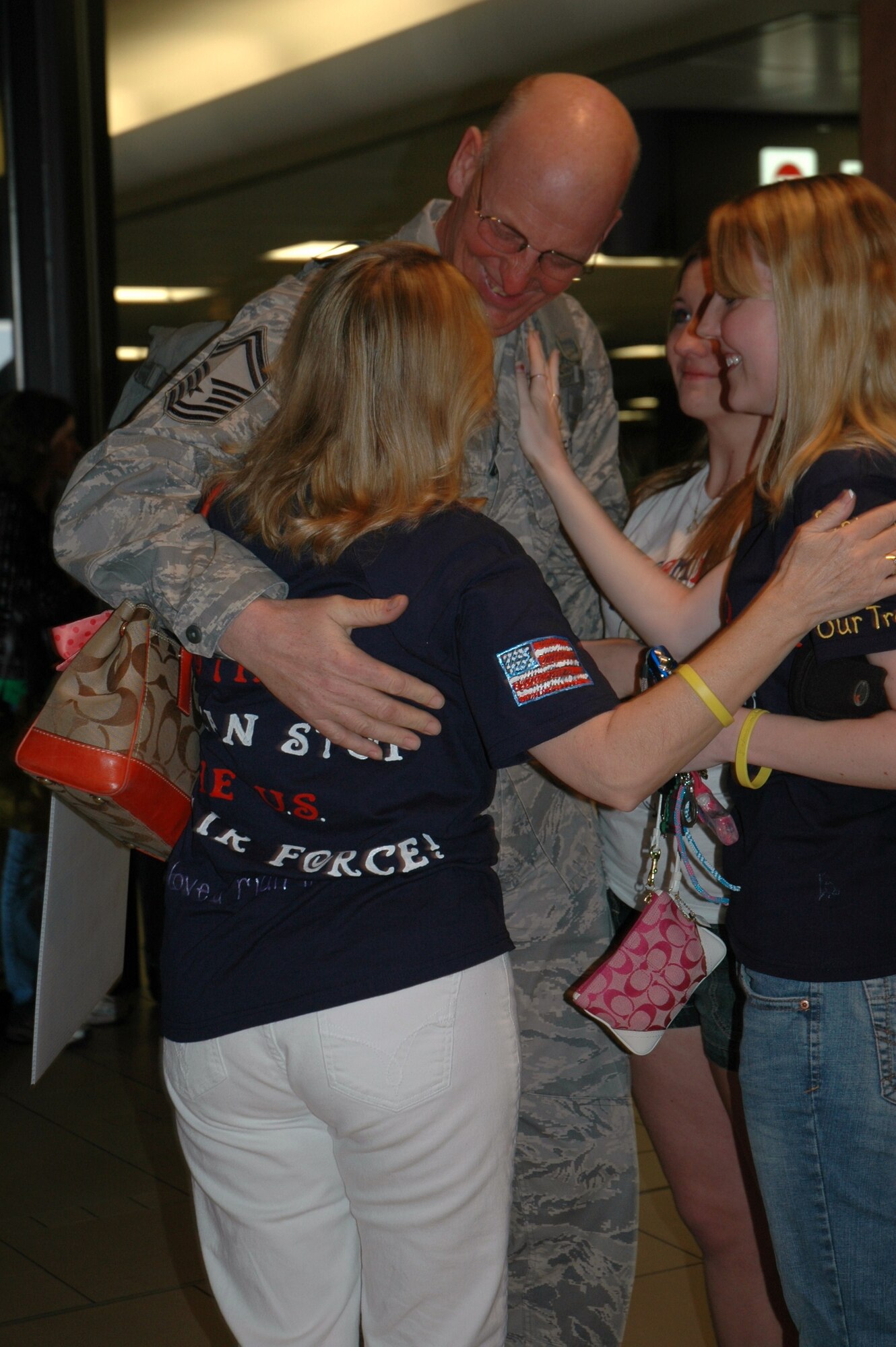 Senior Master Sgt. Jan Dourlein, 944th Civil Engineer Squadron member, is greeted by his wife and daughters March 17 at Phoenix Sky Harbor International Airport after returning from a deployment at Kirkuk Regional Air Base, Iraq. Sergeant Dourlein, along with 23 other reservists from the 944th CES, spent six months away from their families and civilian jobs in support of the Global War on Terrorism. (U.S. Air Force photo/Tech. Sgt. Susan Stout)