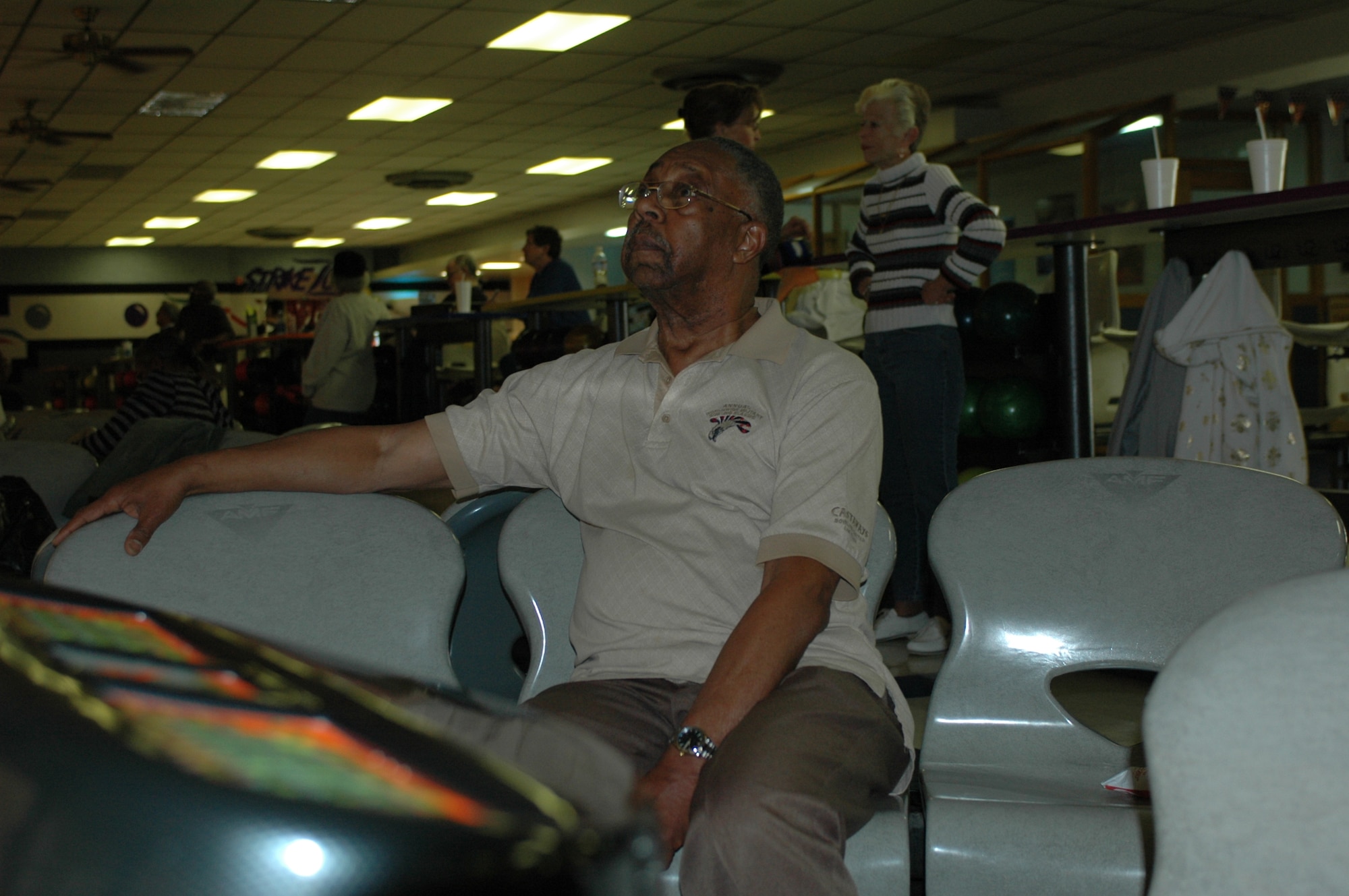 Herb Lewis looks at the scoring screen in the "pit" area of lanes Nos. 15 and16 on March 16, at the Travis Bowling Center. The chairs in which Mr. Lewis sits are scheduled for removal in May, with soft, vinyl couches set to supplant them. (U.S. Air Force photo/Nick DeCicco)
