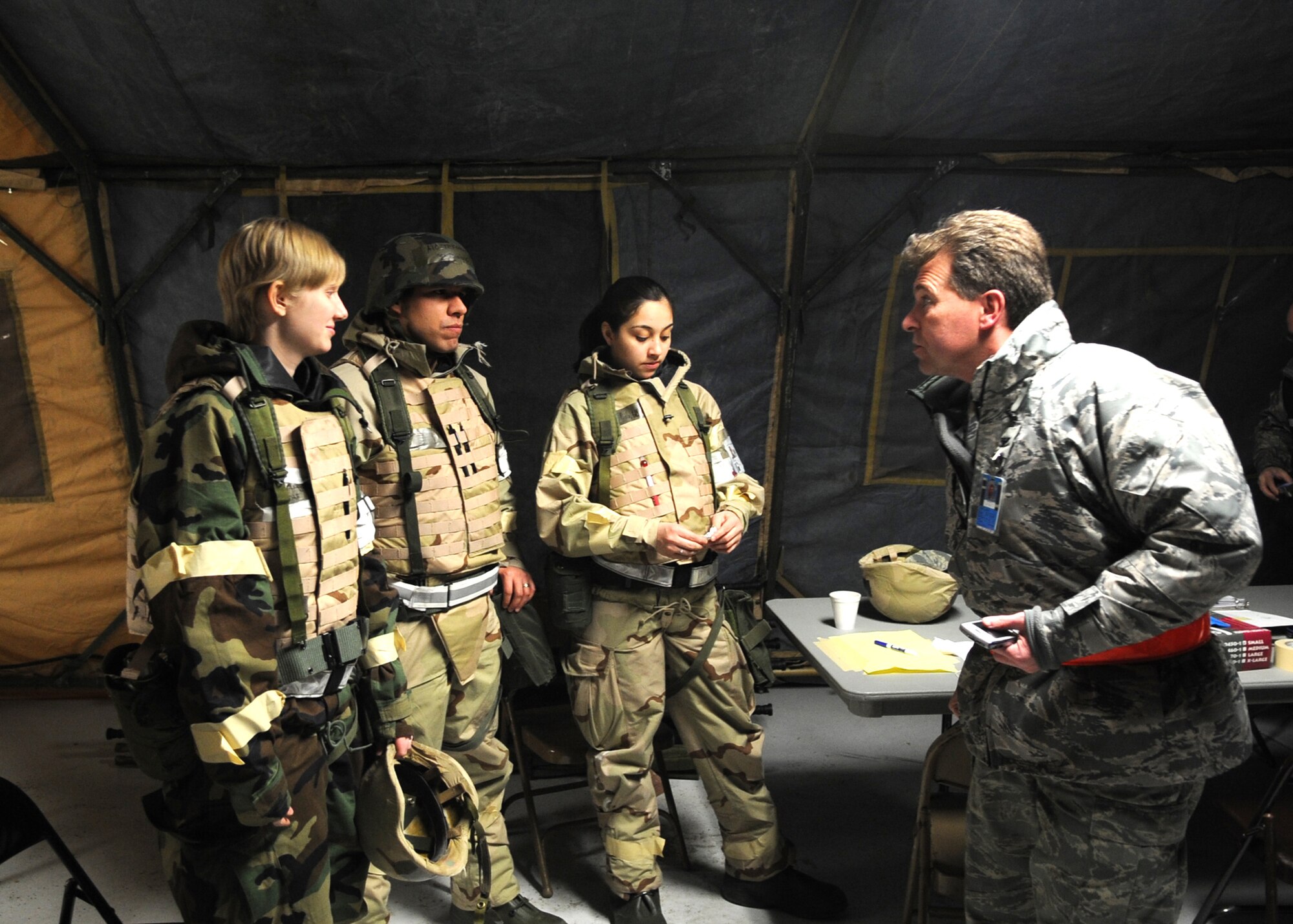 Col. John Michel, 319th Air Refueling Wing commander, talks with troops from the 319th Medical Group during an operational readiness exercise here March 9. Colonel Michel passed out candy to the troops and asked quized the "deployed" Airmen on their ability to survive and operate throughout the exercise. (Photo/Staff Sgt. Suellyn F. Nuckolls)