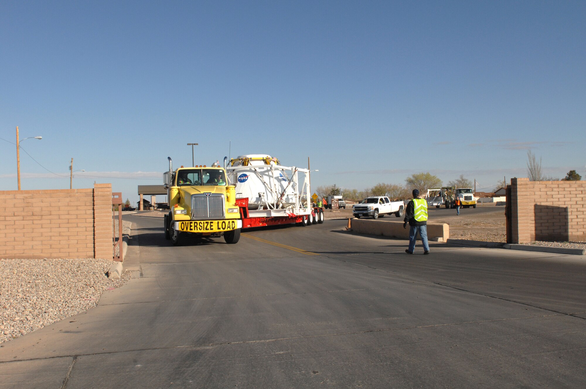 A convoy escorting a NASA crew module Pathfinder unit exits Holloman Air Force Base's west gate, on March 13, 2009. New Mexico State Police provided an escort to White Sands Missile Range where the unit will be tested. (U.S. Air Force/Senior Airman Russell Scalf)