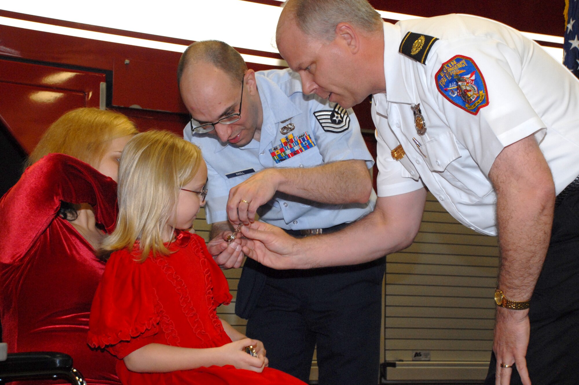 EGLIN AIR FORCE BASE, Fla. -- Victoria Kroll, a 6-year-old child who called 9-1-1 when her mom fell in the bathroom, is presented a fire house coin by Mark Giuliano, Eglin Fire Department chief, during a ceremony at Station 1 March 16. The Eglin Fire Department and the 96th Civil Engineer Group honored Victoria, daughter of Tech. Sgt. Shawn Kroll, 1st Special Operations Maintenance Squadron, and Angie, as the youngest and newest member of the team for her bravery made her an honorary firefighter. (U.S. Air Force photo by Staff Sgt. Mike Meares)