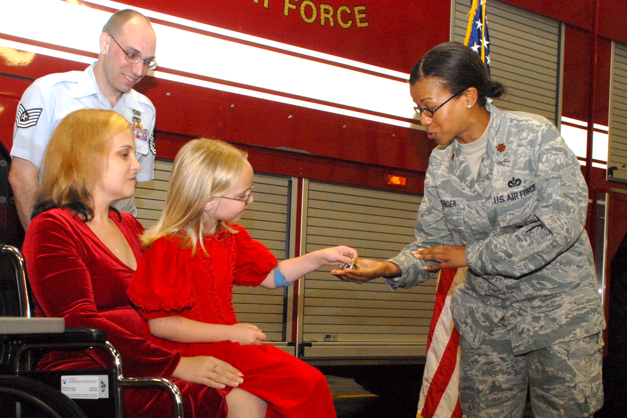 EGLIN AIR FORCE BASE, Fla. -- Victoria Kroll, a 6-year-old child who called 9-1-1 when her mom fell in the bathroom, is presented a squadron coin by Maj. Yvonne Spencer, 96th Civil Engineer Squadron commander, during a ceremony at Station 1 March 16. The Eglin Fire Department and the 96th Civil Engineer Group honored Victoria, daughter of Tech. Sgt. Shawn Kroll, 1st Special Operations Maintenance Squadron, and Angie, as the youngest and newest member of the team for her bravery made her an honorary firefighter. (U.S. Air Force photo by Staff Sgt. Mike Meares)