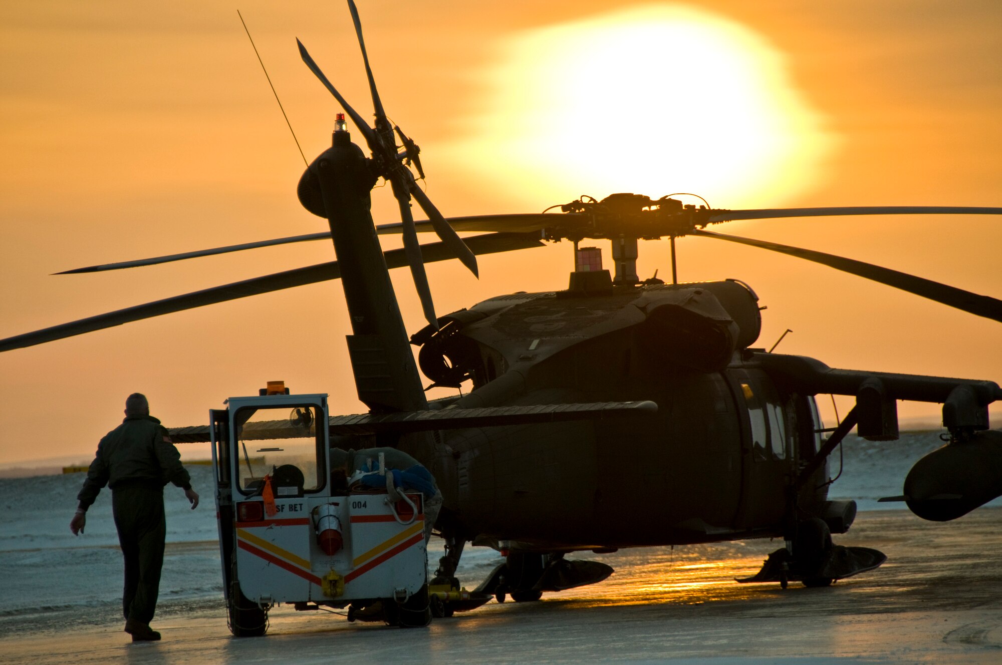 Sgt. 1st Class James Morris of the 1st 207 Aviation Regiment tows a Black Hawk helicopter that will transport an Army Veterinary Corps team to the village of Alakanuk, Alaska, on March 7, 2009. Operation Arctic Care is a joint military medical readiness exercise that brings no-cost health care to underserved Alaskan residents, including dental, optometry and veterinary support. This year's Navy-led mission has teams in 11 villages in Western Alaska's Yukon-Kuskokwim Delta region. Two Air Force Reservists from the 931st Air Refueling Group, Lt. Col. Cheryl Hooper and Lt. Col. (Dr.) James Clark, are currently deployed to Alaska in support of Arctic Care. (U.S. Air Force photo/Senior Airman Christopher Griffin)