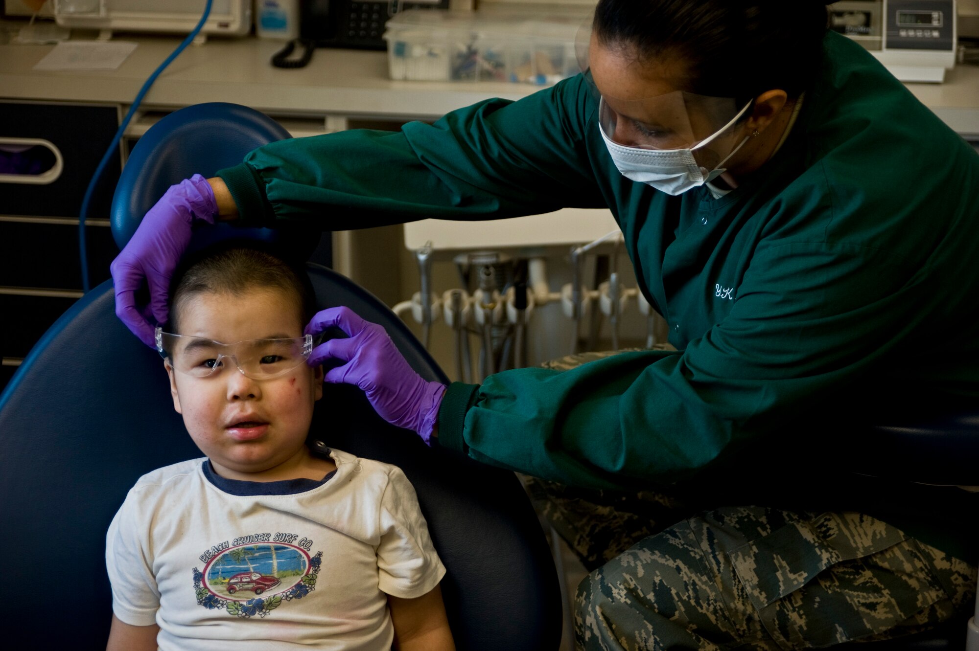 Tech. Sgt. Kristie Subieta, a dental hygenist assigned to the 507th Medical Squadron at Tinker Air Force Base, adjusts protective eye glasses on Dylon Sergie, 2, at a health clinic in Kwethluk, Alaska, on March 10. Kwethluk is one of 11 villages in Alaska's Yukon-Kuskokwim Delta region included in Operation Arctic Care, a joint military mission that provides medical, dental and veterinary support at no cost to Alaskan natives. Two Air Force Reservists from the 931st Air Refueling Group, Lt. Col. Cheryl Hooper and Lt. Col. (Dr.) James Clark, are currently deployed to Alaska in support of Arctic Care. (U.S. Air Force/Senior Airman Christopher Griffin)
