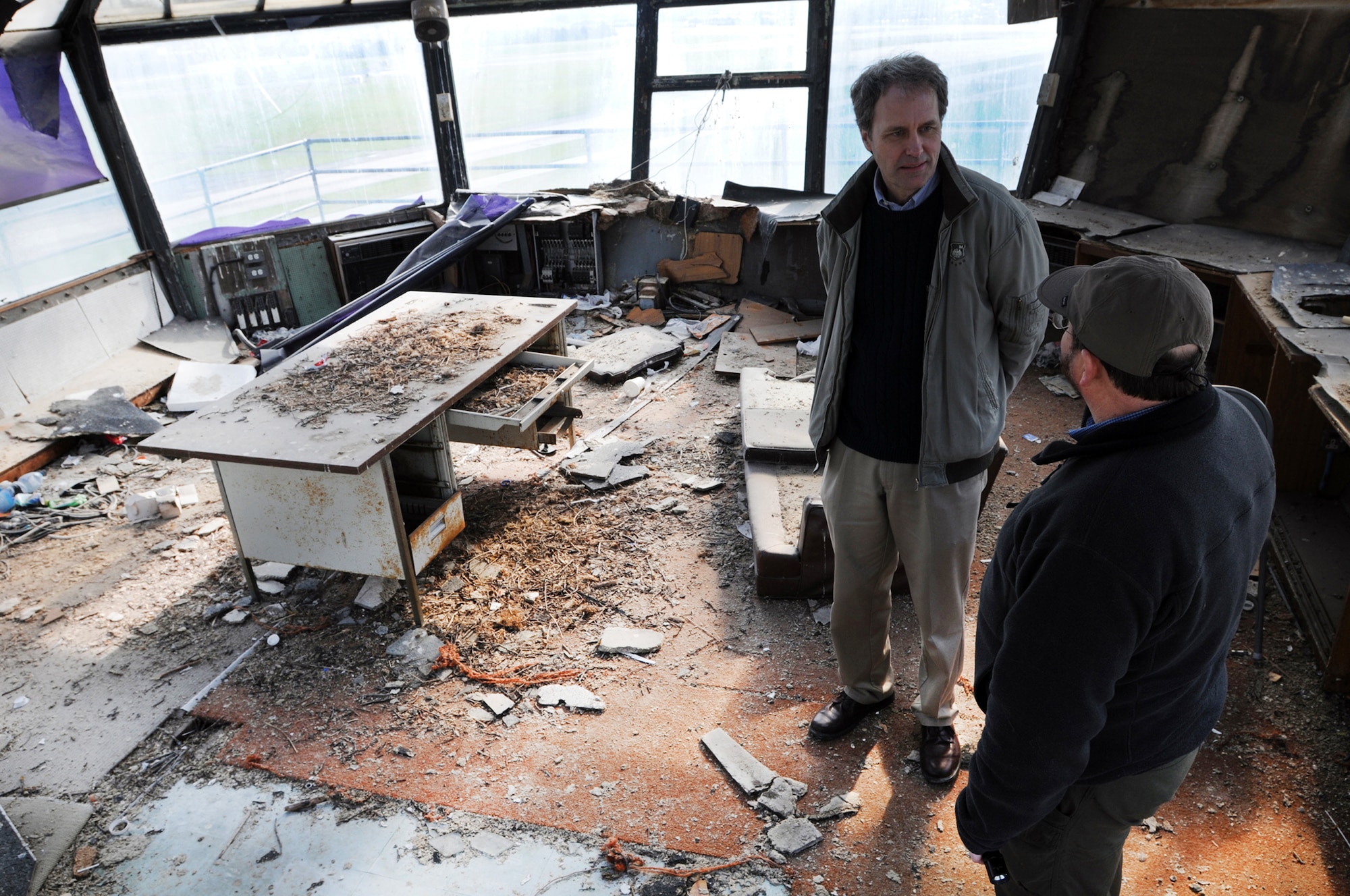 Bill Harris (wearing hat), 48th Fighter Wing Historian discusses some of the intricate details of the old air traffic control tower at Royal Air Force Lakenheath, England, with Joe Koziar, a local fourth-grade school teacher. They were taking a final look Feb. 27 to document the building before it's demolished. The tower has fell into disarray since being abandoned in 1992. (U.S. Air Force photo/Staff Sgt. Nathan Gallahan) 