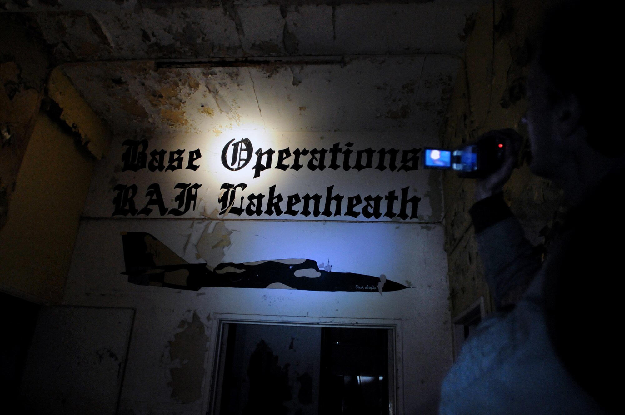 Joe Koziar, a local fourth-grade school teacher, documents his visit to the old air traffic control tower at Royal Air Force Lakenheath, England, Feb. 27. The "Base Operations RAF Lakenheath" mural highlights the Liberty Wing's heritage with the tower, although the tower was constructed in 1946, and the wing wasn't assigned here until 1960. The tower is set to be demolished. (U.S. Air Force photo/Staff Sgt. Nathan Gallahan)