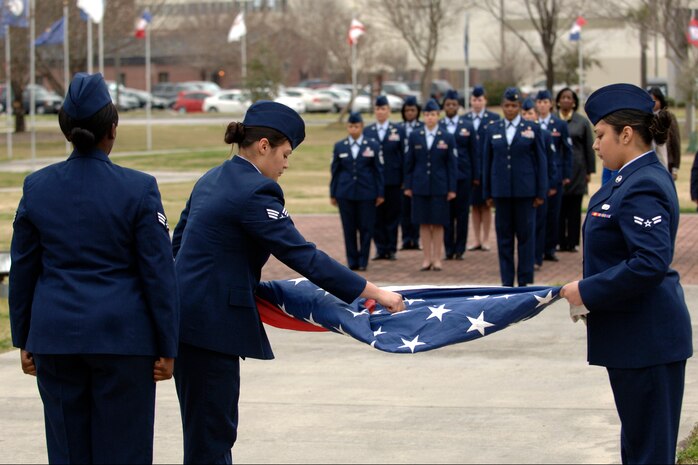 Base honor guard members fold the flag during the all-women retreat ceremony here March 13. National Women's History Month recognizes the accomplishments of women in America. (U.S. Air Force photo/Senior Airman Timothy Taylor)