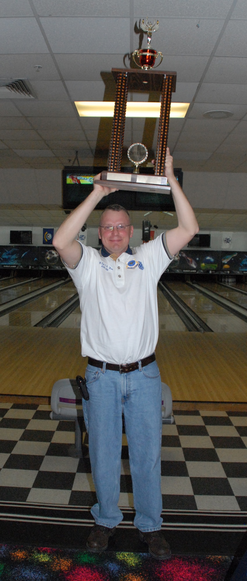 Chief Master Sgt. John Wood, 436th Airlift Wing command chief, celebrates with the 1st place trophy after the Chiefs vs. Eagles bowling tournament.  (U.S. Air Force photo/Staff Sgt. Chad Padgett)