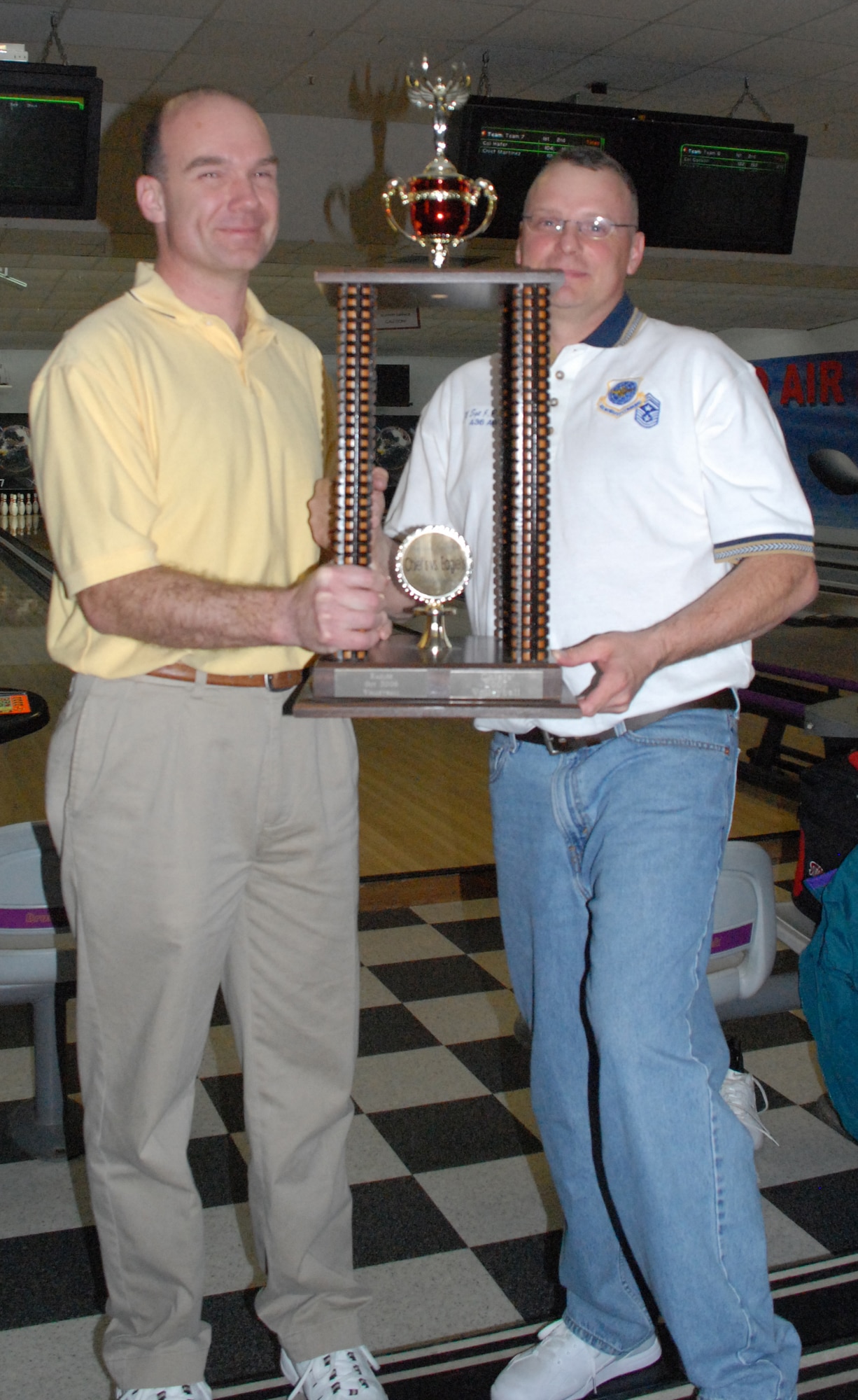 Col. Manson Morris, 436th Airlift Wing commander, hands Chief Master Sgt. John Wood, 436th AW command chief, the 1st place trophy after the Chiefs vs. Eagles bowling tournament.  (U.S. Air Force Photo/Staff Sgt. Chad Padgett)