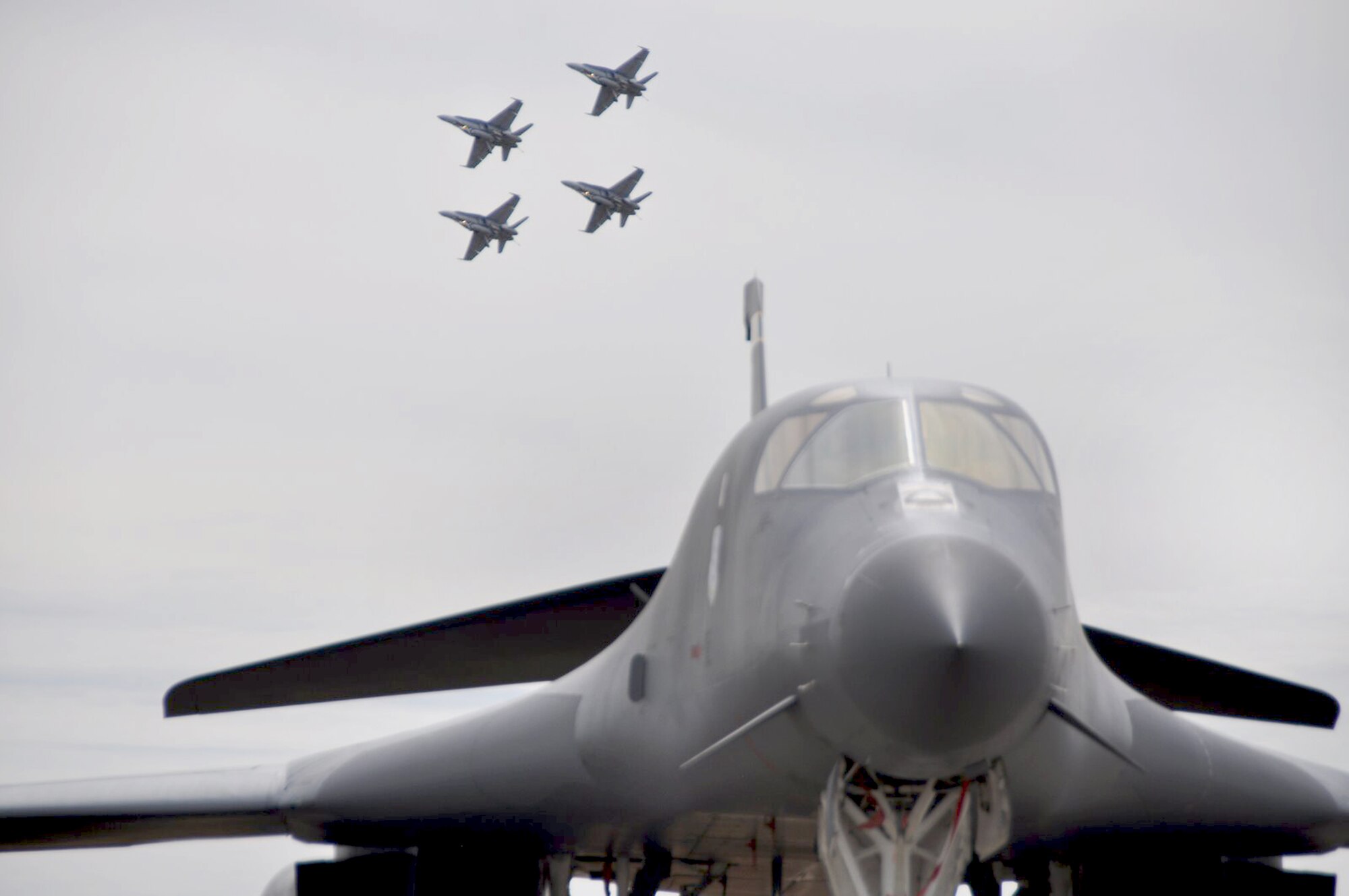A B-1B Lancer sits on display while four Royal Australian Air Force F/A-18s practice for an upcoming performance at the 2009 Australian International Airshow March 12 at Avalon Airport, Australia. The B-1B is from the 37th Bomber Squadron from Ellsworth Air Force Base, S.D. (U.S. Air Force photo/Tech. Sgt. Cohen A. Young) 