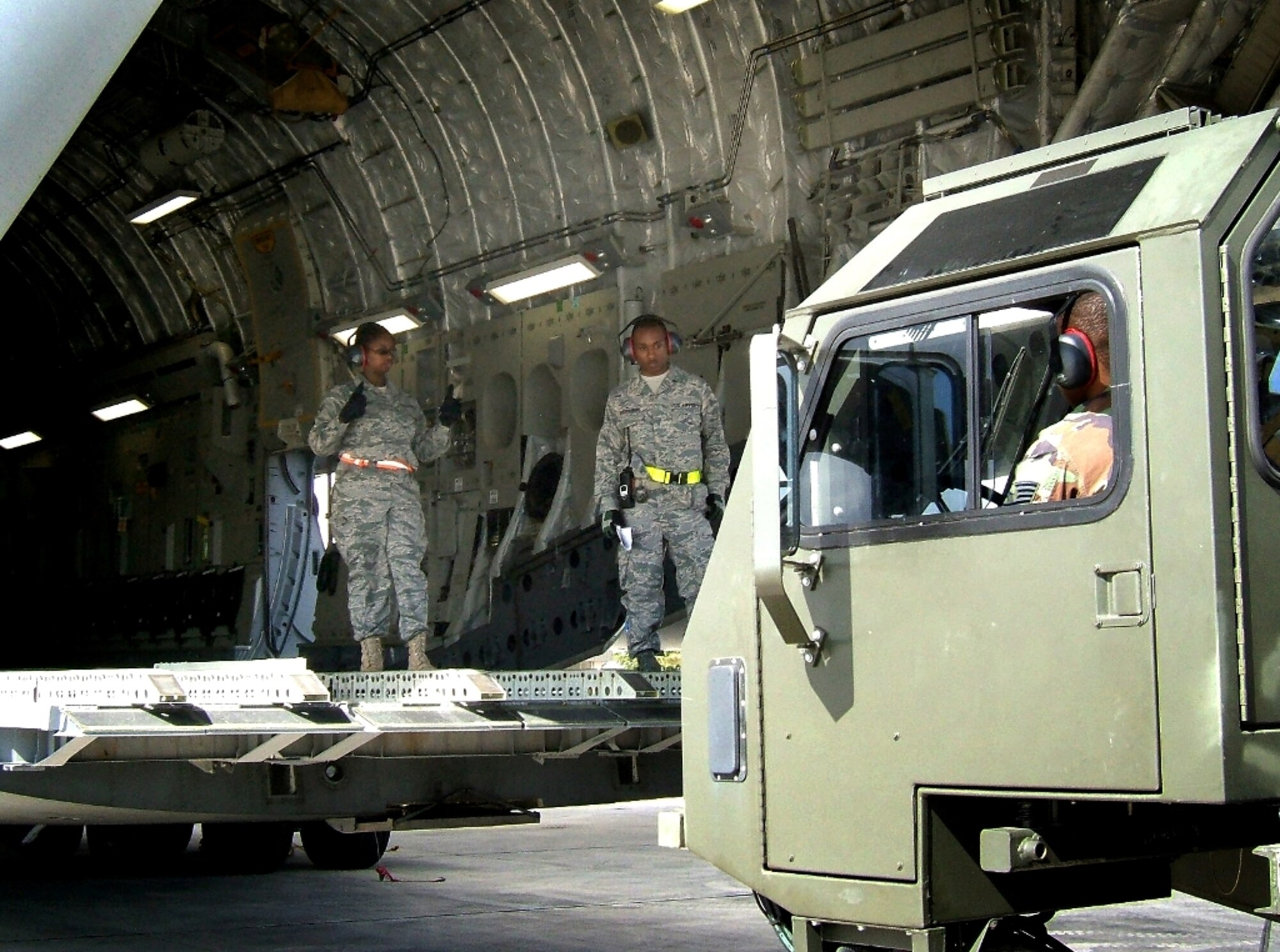 Staff Sgt. Lawatha Cherrenfro (right) oversees Senior Airman Genesis Troutman (left) as she marshals in a 25,000-pound loader up to a C-17 Globemaster during a training exercise on the March Unit Training Assembly. The C-17 was flown to Homestead to serve as a static trainer to prepare aerial porters for future deployments. A large contingent from the 70th APS is currently deployed to Kirkuk Regional Air Base, Iraq, where they are directly supporting U.S. and Coalition ground forces. There, the reservists are loading and unloading military transport aircraft, tracking supplies and equipment, and processing passengers traveling in and out of Iraq. (U.S. Air Force photo/Tech. Sgt. Robert Gibson)