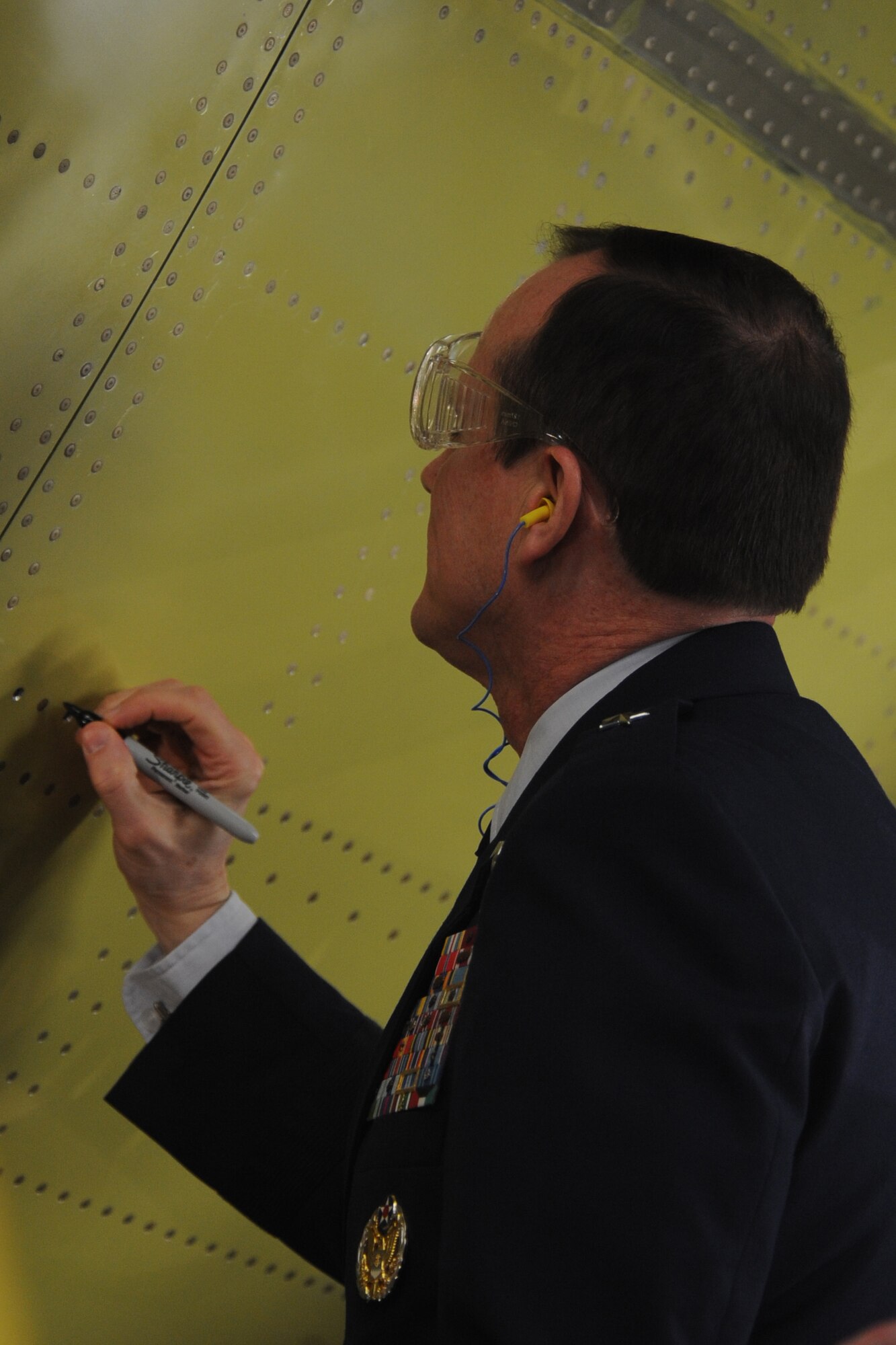 In his multinational role as chairman of the 12-nation Strategic Airlift Capability consortium, Brig. Gen. Richard Johnston signed the forward fuselage of the program's first C-17 after having driven a ceremonial rivet into the airframe during the "major join" ceremony at the Boeing final assembly facility.  The C-17 will be delivered to the Heavy Airlift Wing, the SAC program's multinational operational unit, at Papa Air Base, Hungary, in July. (U.S. Air Force photo by Atiba Copeland)