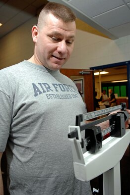 Staff Sgt. Kevin Pike, 28th Bomb Wing chaplain assistant, carefully weighs himself during the final weigh-in for the Bellamy Fitness Center's "Biggest Loser" competition, March 10. Sergeant Pike competed against 70 other participants to win the title of the fitness center's "Biggest Loser." (U.S. Air Force photo/Airman 1st Class Abigail Klein)