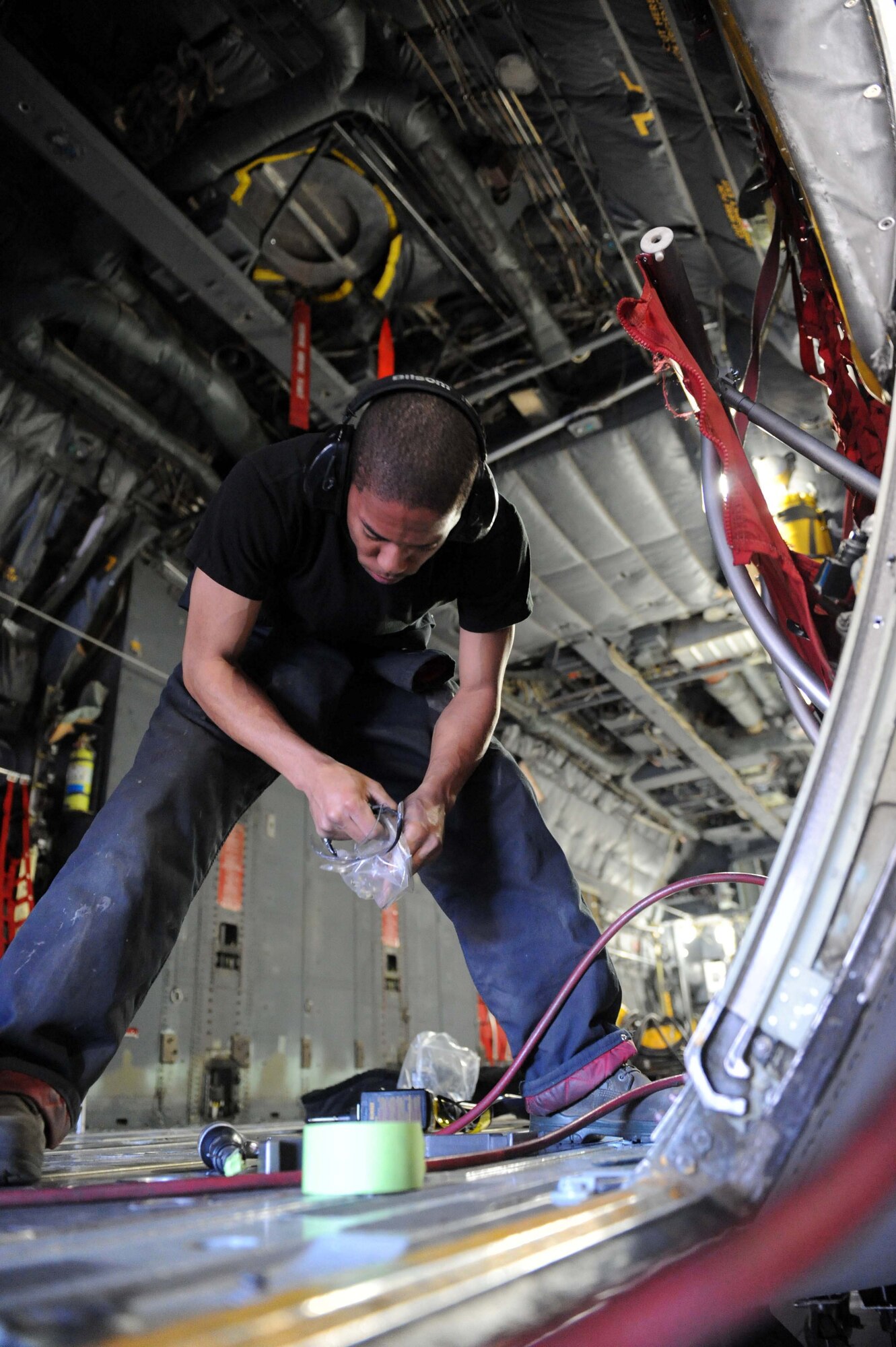 DYESS AIR FORCE BASE, TX-- Airman First Class D'Jon Green puts safety gear on before dealing with any repairs needing to be made on a C-130 here March 17. This C-130 is undergoing repairs as part of an ISO inspection conducted every 450 days. (U.S. Air Force photo by Senior Airman Domonique Simmons)