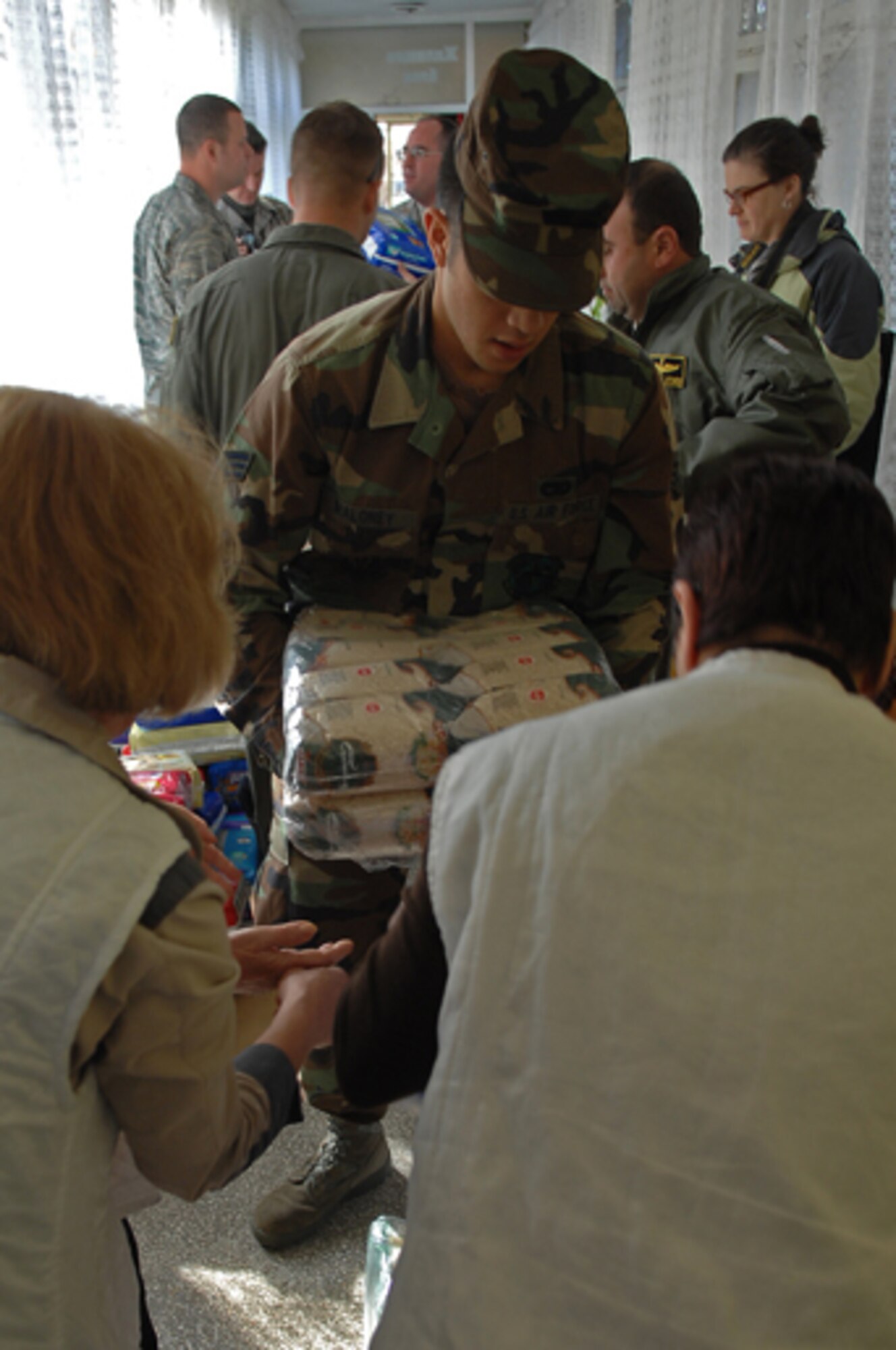 Senior Airman Glenn Maloney, 86th Air Mobility Squadron air transportation journeyman, delivers an arm-full of dry meal to a Bulgarian orphanage in Sliven, Bulgaria. The meal was part of a 1,500 pound donation that U.S. forces donated to the Bulgarian orphanage in coordination with a visit there during Operation Thracian Spring, Bezmer Air Base, Bulgaria, March 12, 2009. This exercise is conducted annually since 2007, Operation Thracian Spring is a two week exercise allowing U.S. forces an opportunity to train and interact with their Bulgarian counterparts. (U.S. Air Force photo by Airman 1st Class Tony R. Ritter) 