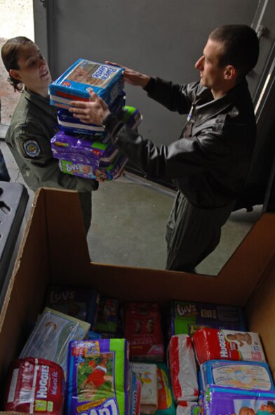 1st Lt. Taylor Sciulli (left) and 1st Lt. Brad Crosson, 37th Airlift Squadron C-130 co-pilots, unload a cargo container filled with diapers, wipes, and baby cosmetics on Bezmer Air Base, Bulgaria. The care items are part of a 1,500-pound donation that U.S. forces donated to a Bulgarian orphanage in coordination with a visit there during Operation Thracian Spring, March 12, 2009. This exercise is conducted annually since 2007, Operation Thracian Spring is a two week exercise allowing U.S. forces an opportunity to train and interact with their Bulgarian counterparts. (U.S. Air Force photo by Airman 1st Class Tony R. Ritter) 