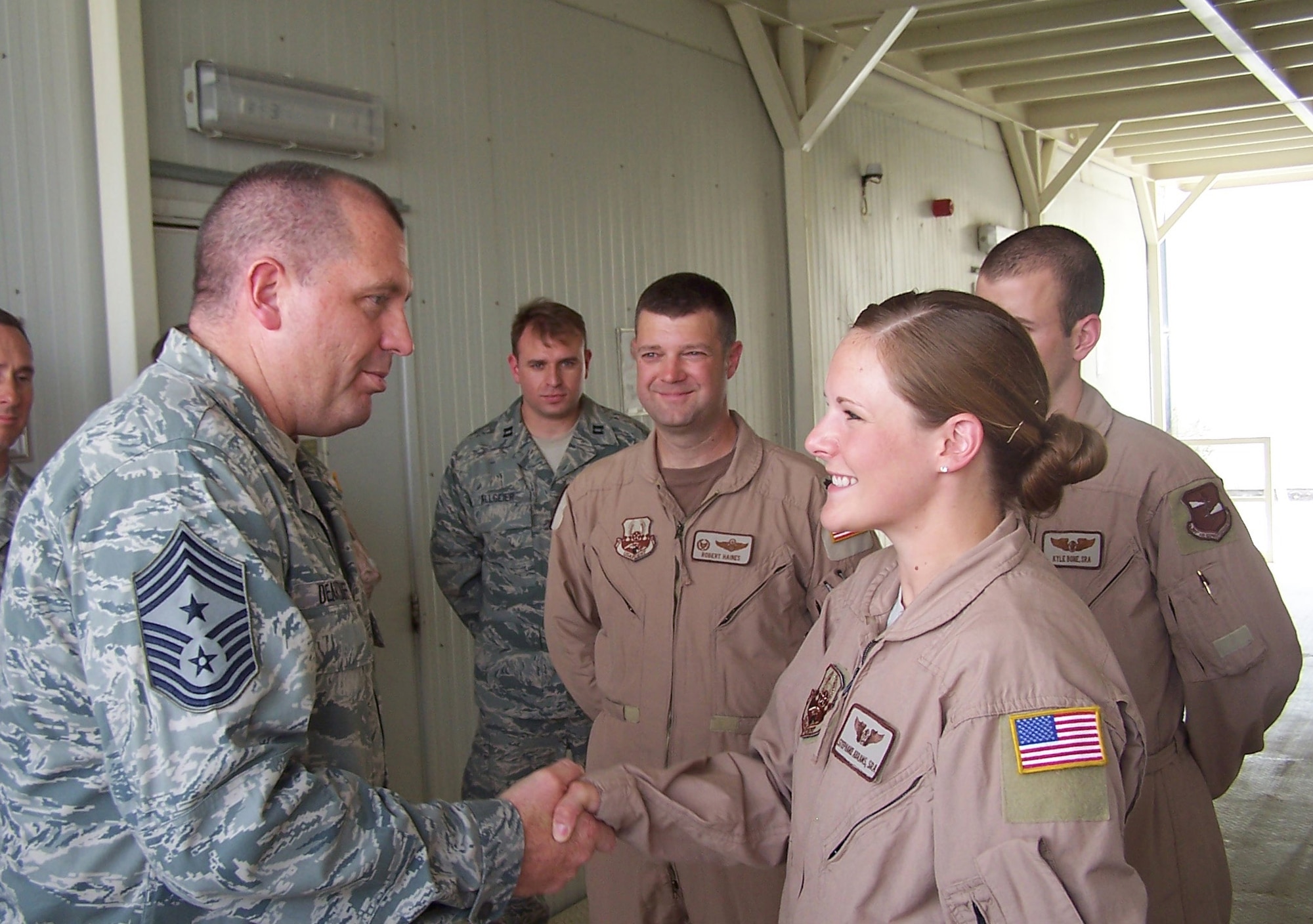 SOUTHWEST ASIA -- Chief Master Sgt. Scott Dearduff, U.S. Air Forces Central Command Chief, coins Senior Airman Stephanie Abrams for outstanding performance during a recent visit here. Chief Dearduff spent some time with 380th Air Expeditionary Wing Airmen to put "eyes on" the current mission, view recent mission expansions and speak at the Chief Recognition Ceremony. (Courtesy photo) (Released)