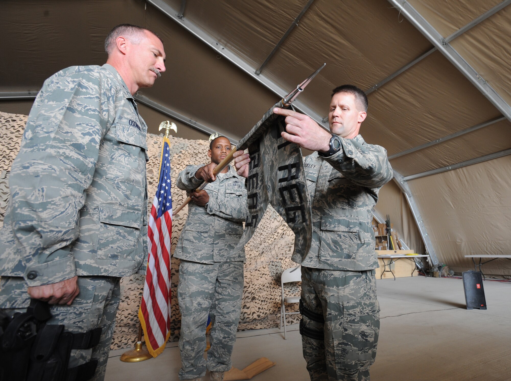 U.S. Air Force Lt. Col. Dan Tully unravels the new 772nd Expeditionary Airlift Squadron guide-on during the activation ceremony at Kandahar Air Field, Afghanistan, March 14, 2009, in support of Operation Enduring Freedom.  A new Squadron, the 772nd Expeditionary Airlift Squadron has been set to assist with the increase of U.S. Troops to the region.  (U.S. Air Force photo by Staff Sgt. James L. Harper Jr.)