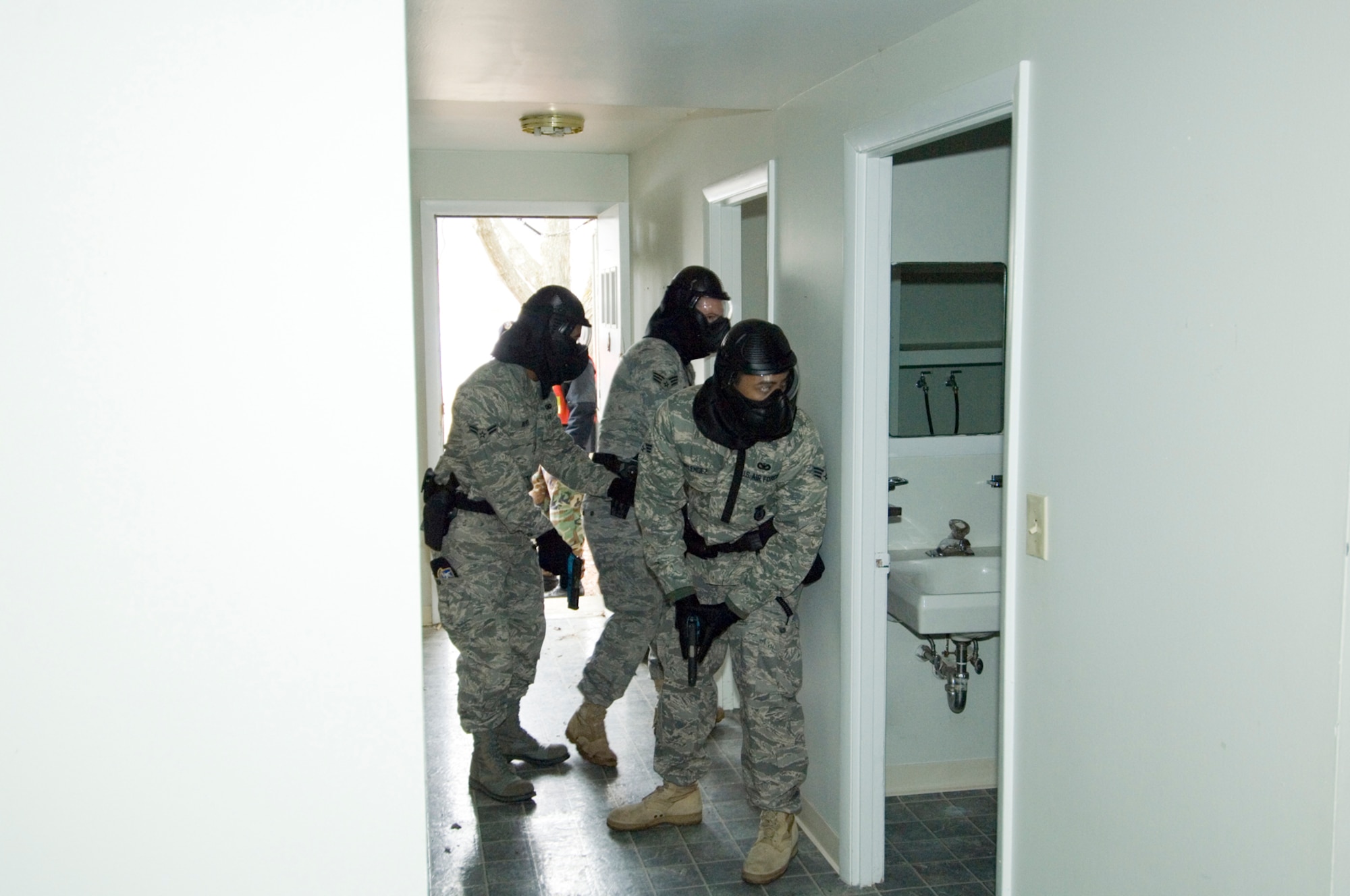 HANSCOM AIR FORCE BASE, Mass. – 66th Security Forces Squadron patrolmen practice their search techniques while looking for an armed suspect during the first Joint Police Training exercise on March 16. The training provided an opportunity for SFS patrolmen and members of the Lexington, Mass., Police Department to train side by side, enhancing familiarization with each others’ procedures and tactics. Members of the Massachusetts State Police Special Tactical Operations team conducted the training which included the use of Simunitions to make the training as realistic as possible. (U.S. Air Force photo by Rick Berry) 