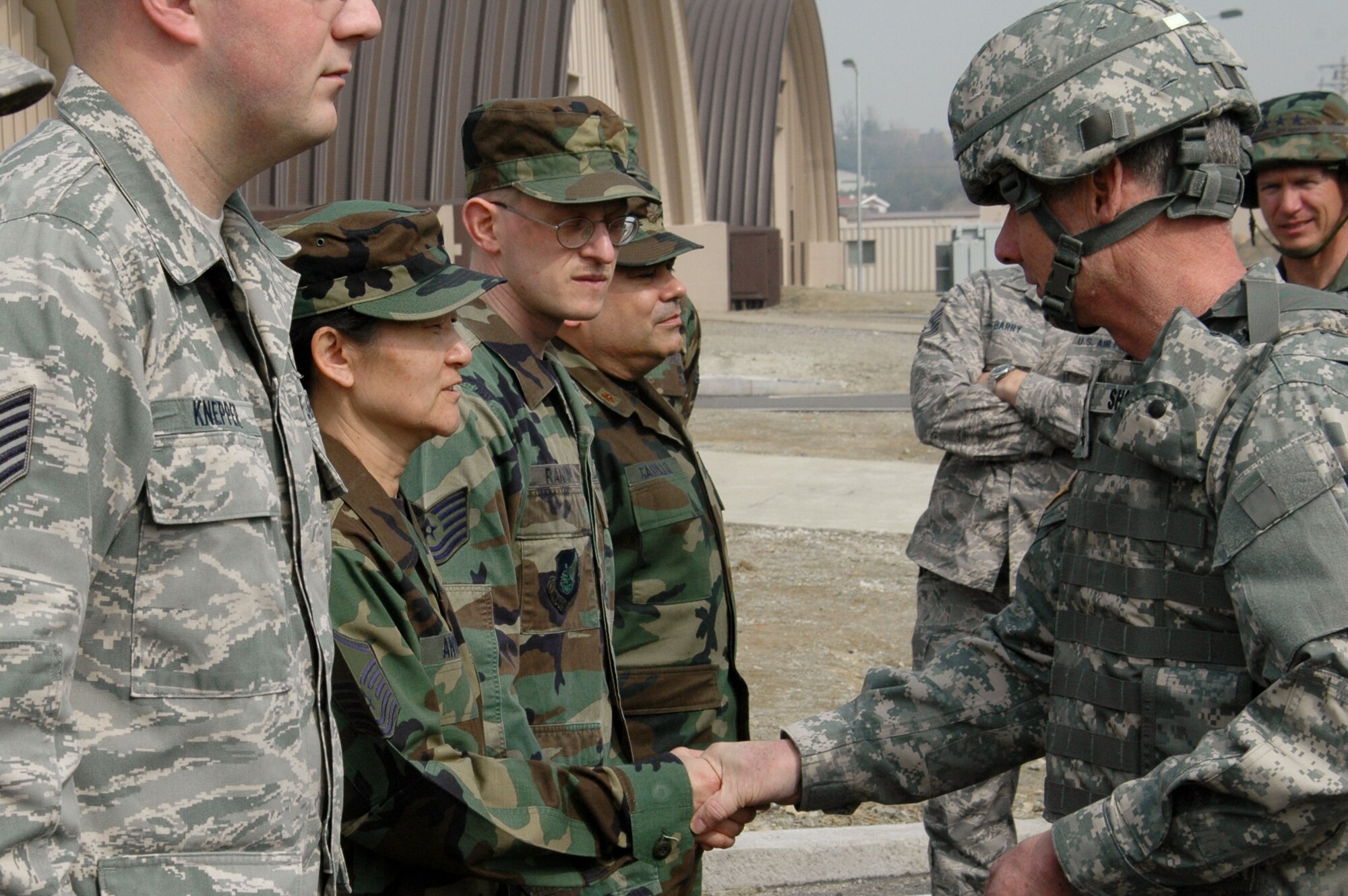 OSAN AIR BASE, Republic of Korea --  Gen. Walter Sharp, U.S. Forces Korea commander, presents a coin for excellence to Master Sgt. Inok Antunes, services superintendent, at Rush Park tent city here March 16. Sergeant Antunes led the team that set up the tent city facilities for more than 600 Soldiers, Sailors, Airmen and Marines participating in the peninsula-wide exercise Key Resolve/Foal Eagle 09. (U.S. Air Force photo/Staff Sgt. Sam Hymas)