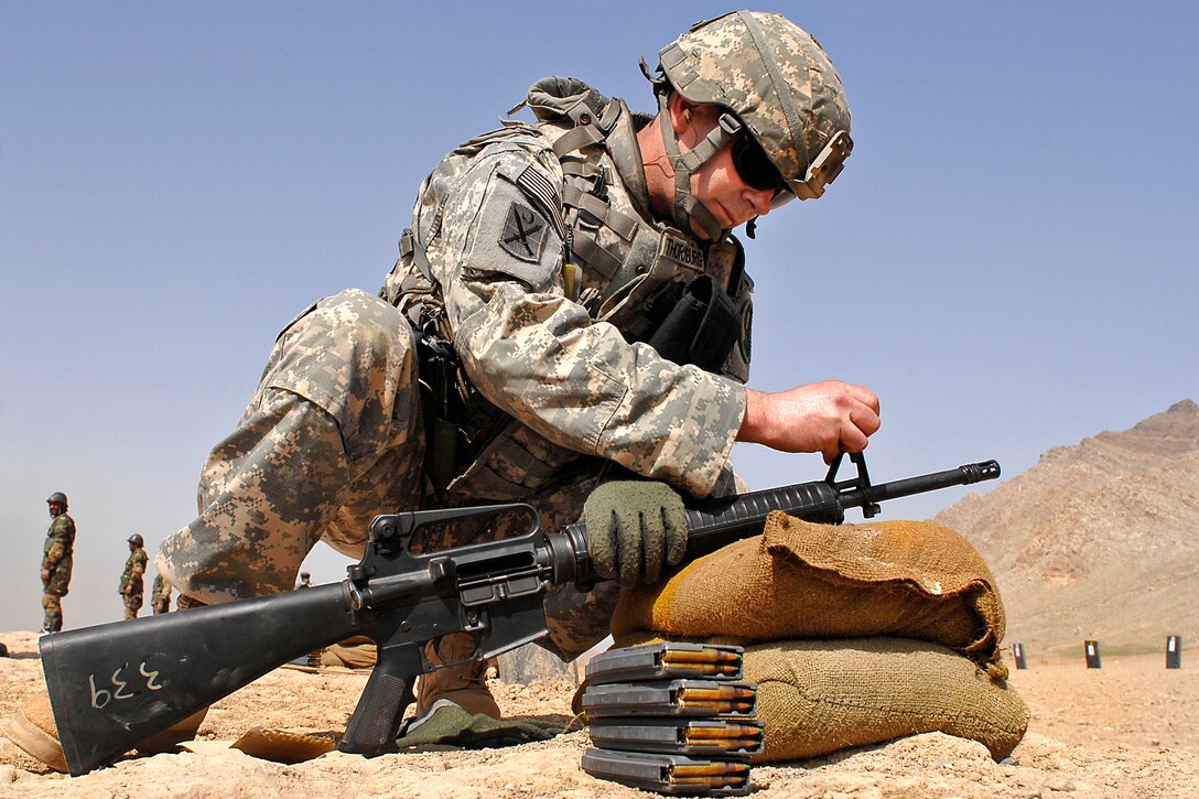 U.S. Army Staff Sgt. Chris Thornburg adjusts the sights on an Afghan soldier's M16 during zeroing on the Kabul Military Training Center, Afghanistan, March 17, 2009. Thornburg is assigned to Camp Alamo Mentor Group's Basic Warrior Training Branch and mentors Afghan recruits as they learn to use their new M16s.